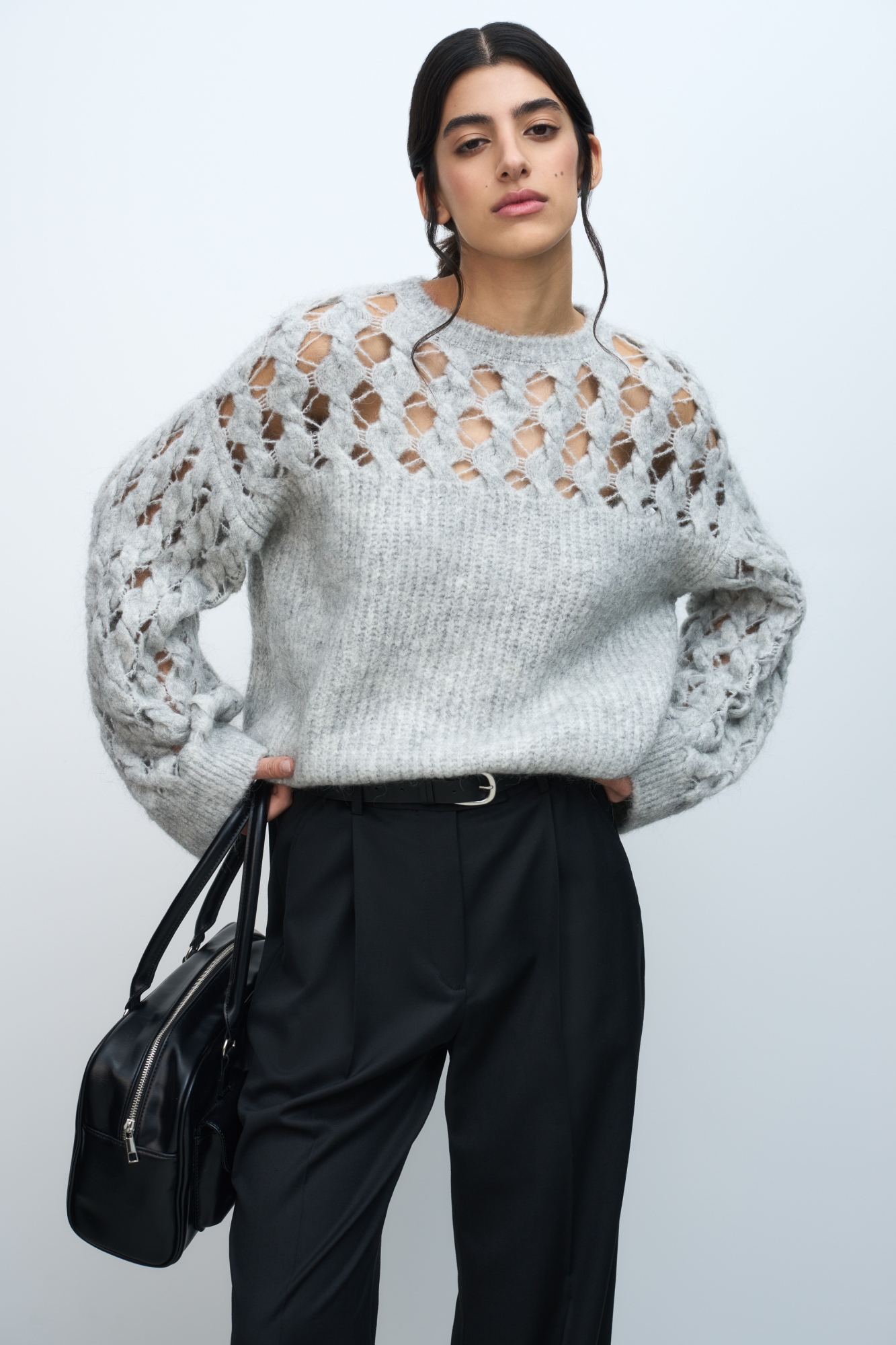 Трикотажный джемпер с фактурным переплетением, состоящим из ажурных кос с перекрутом. Круглый вырез, спущенная линия плеча и широкие рукава.