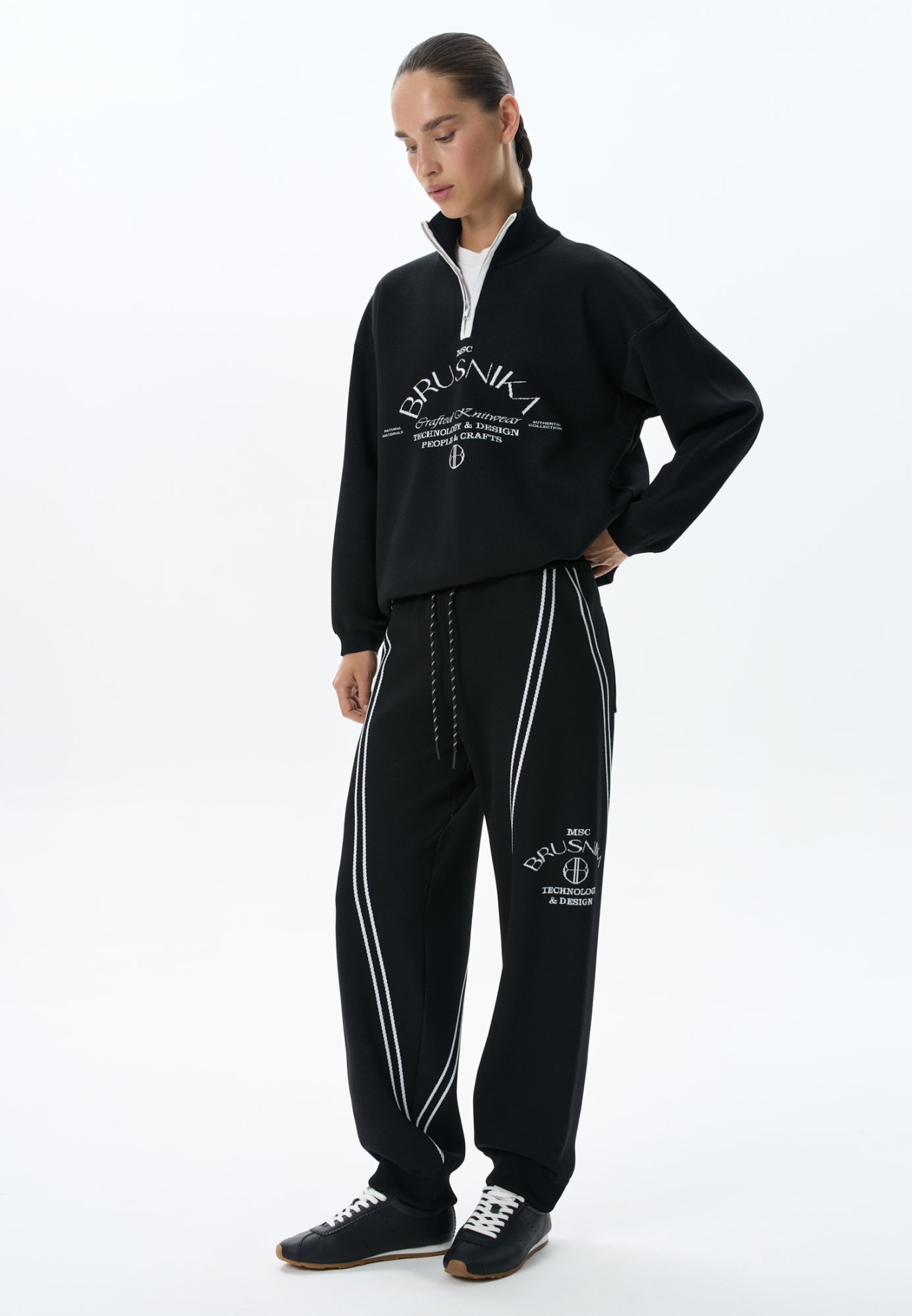 Трикотажные джоггеры из вискозы. Модель свободного силуэта, с широким эластичным поясом на кулиске, боковыми и задними карманами. Изделие декорировано брендированным жаккардом и лампасами контрастного цвета.