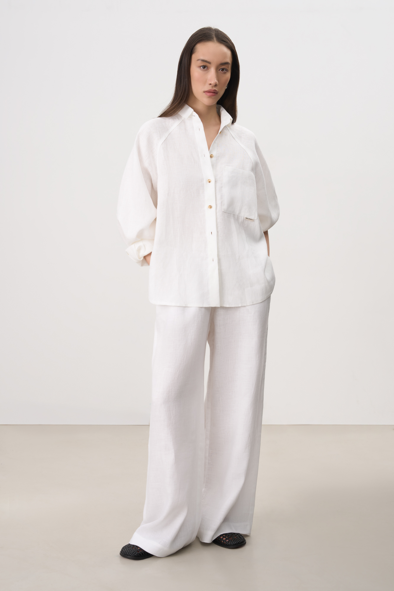 Рубашка из 100% льна с рукавом реглан. Модель свободного кроя, с длинными рукавами с короткими манжетами, классическим отложным воротником и нагрудным карманом с брендированным ярлыком. Застежка на пуговицы.