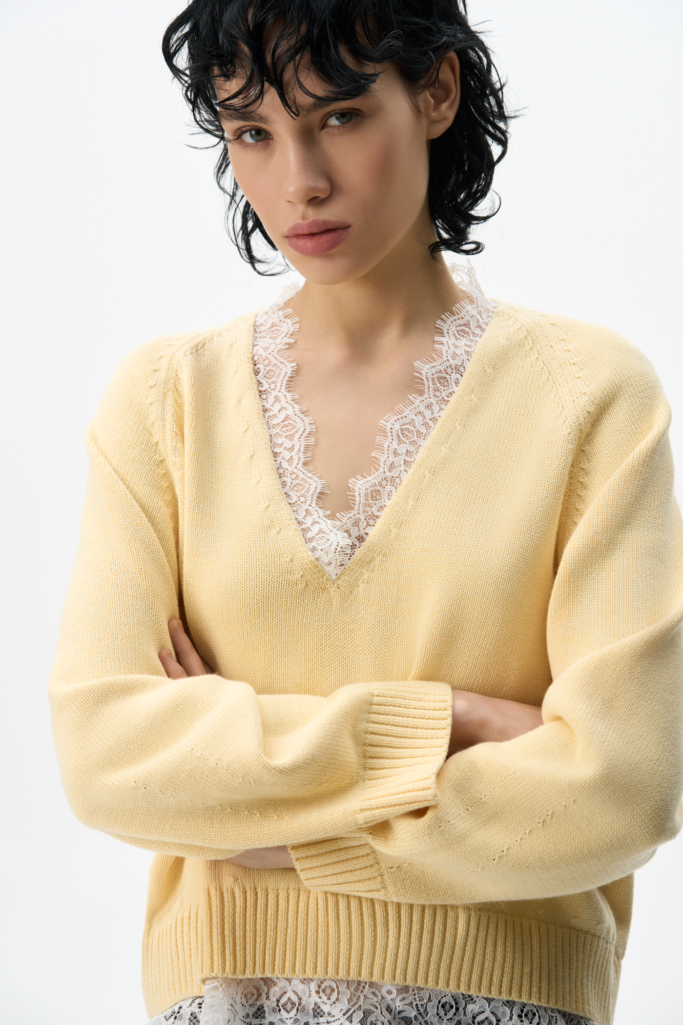 Трикотажный джемпер из 100% хлопка. Модель свободного силуэта с рукавом реглан и V-образным вырезом. Вырез и низ изделия декорированы кружевом контрастного цвета.