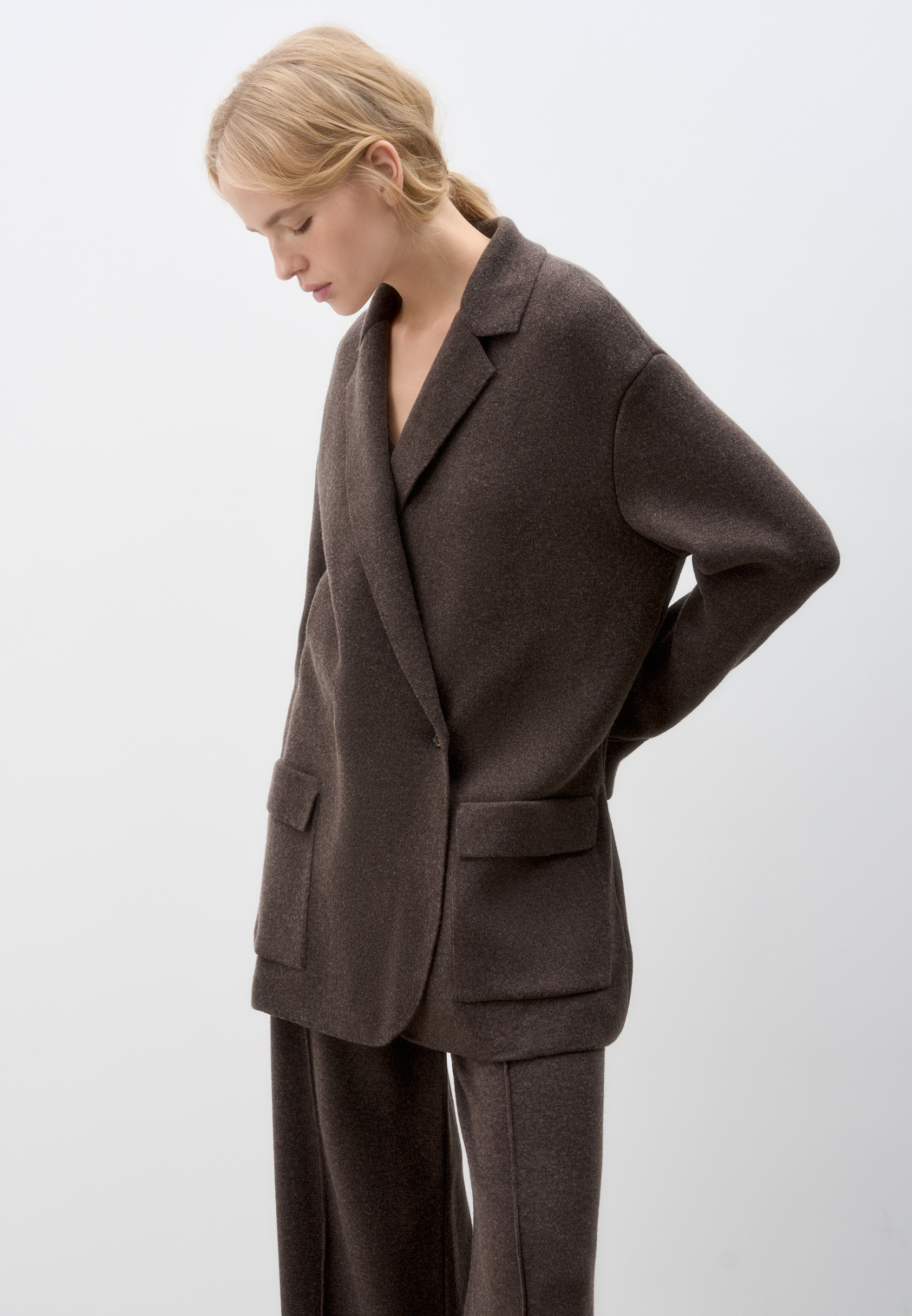 Трикотажный двубортный жакет из смесовой шерсти с добавлением кашемира. Модель прямого кроя, с прямоугольными лацканами и накладными карманами с клапанами спереди. Изделие без подкладки.