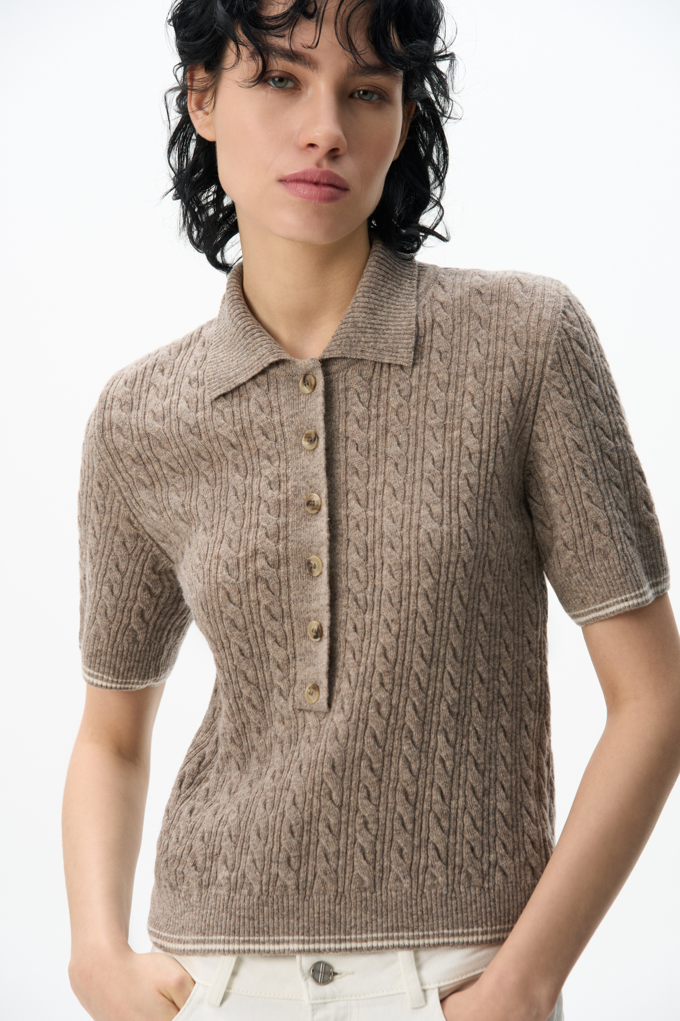 Трикотажная футболка из 100% шерсти. Модель прямого кроя с воротником поло и планкой на пуговицах, края изделия выполнены в мелкий рубчик.