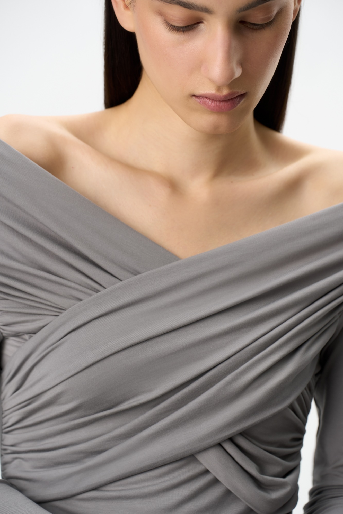 Удлиненный топ с драпировкой на груди. Модель приталенного силуэта с длинным рукавом, выполнена из мягкой и шелковистой ткани. 