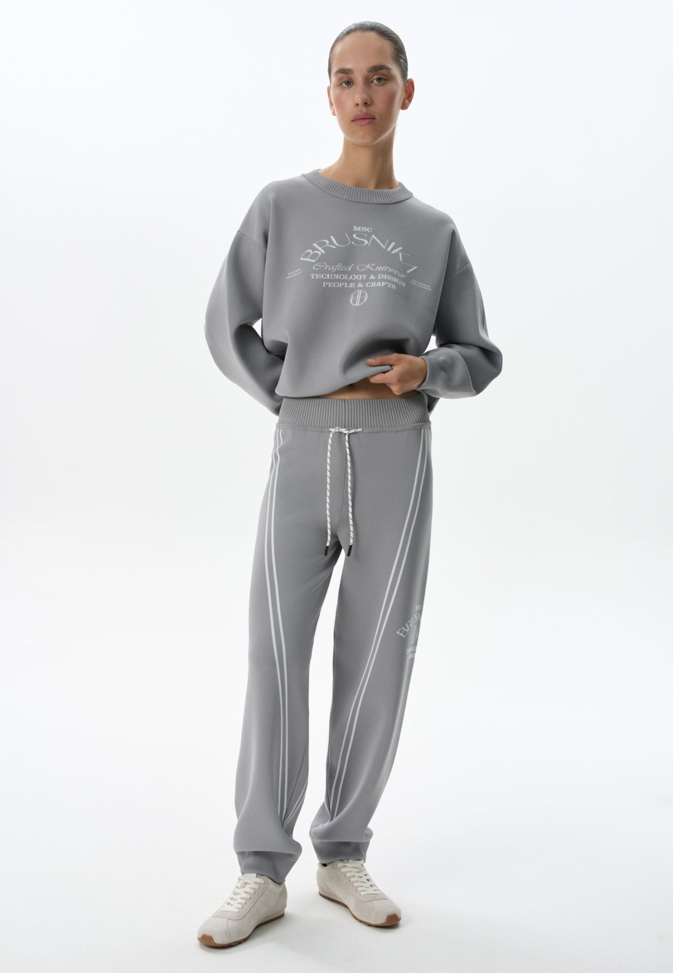 Трикотажные джоггеры из вискозы. Модель свободного силуэта, с широким эластичным поясом на кулиске, боковыми и задними карманами. Изделие декорировано брендированным жаккардом и лампасами контрастного цвета.