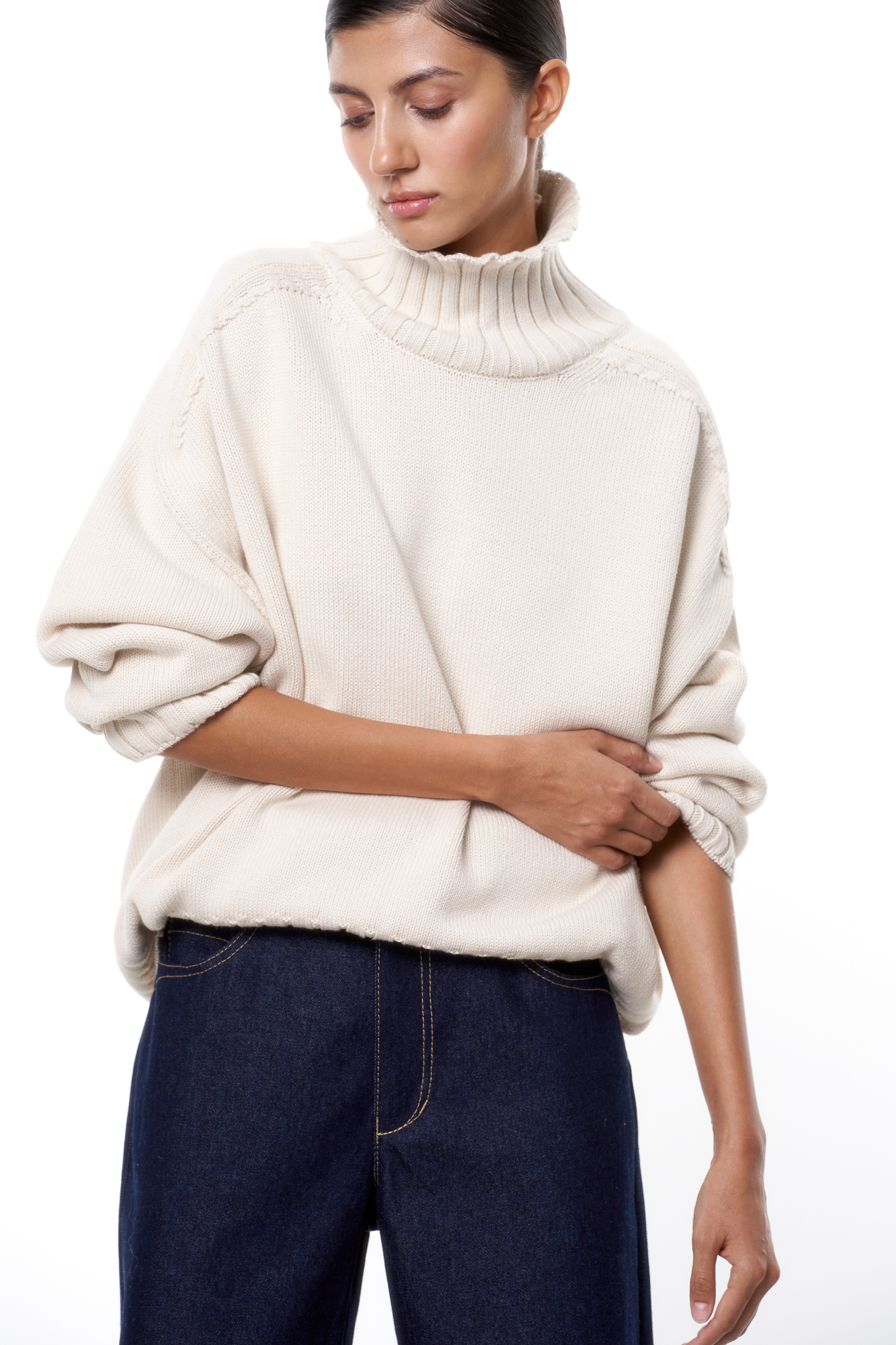 Объемный джемпер крупной вязки из 100% хлопка с высоким горлом. Манжеты и низ изделия в рубчик.