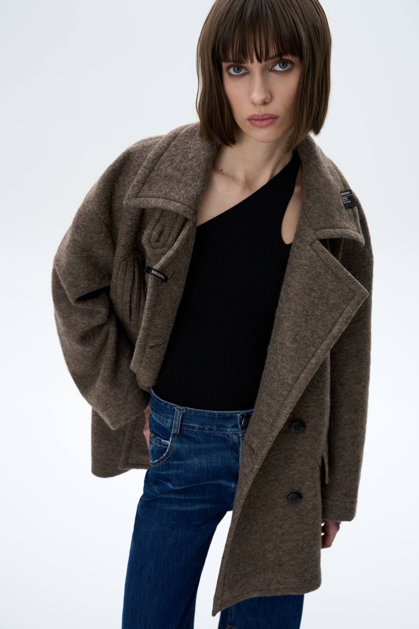 Двубортное пальто из шерсти. Модель прямого кроя со спущенной линией плеч, карманами на груди и накладными карманами с клапанами. Застежка на пуговицы. Изделие декорировано брендированными ярлыками на воротнике. На подкладке.