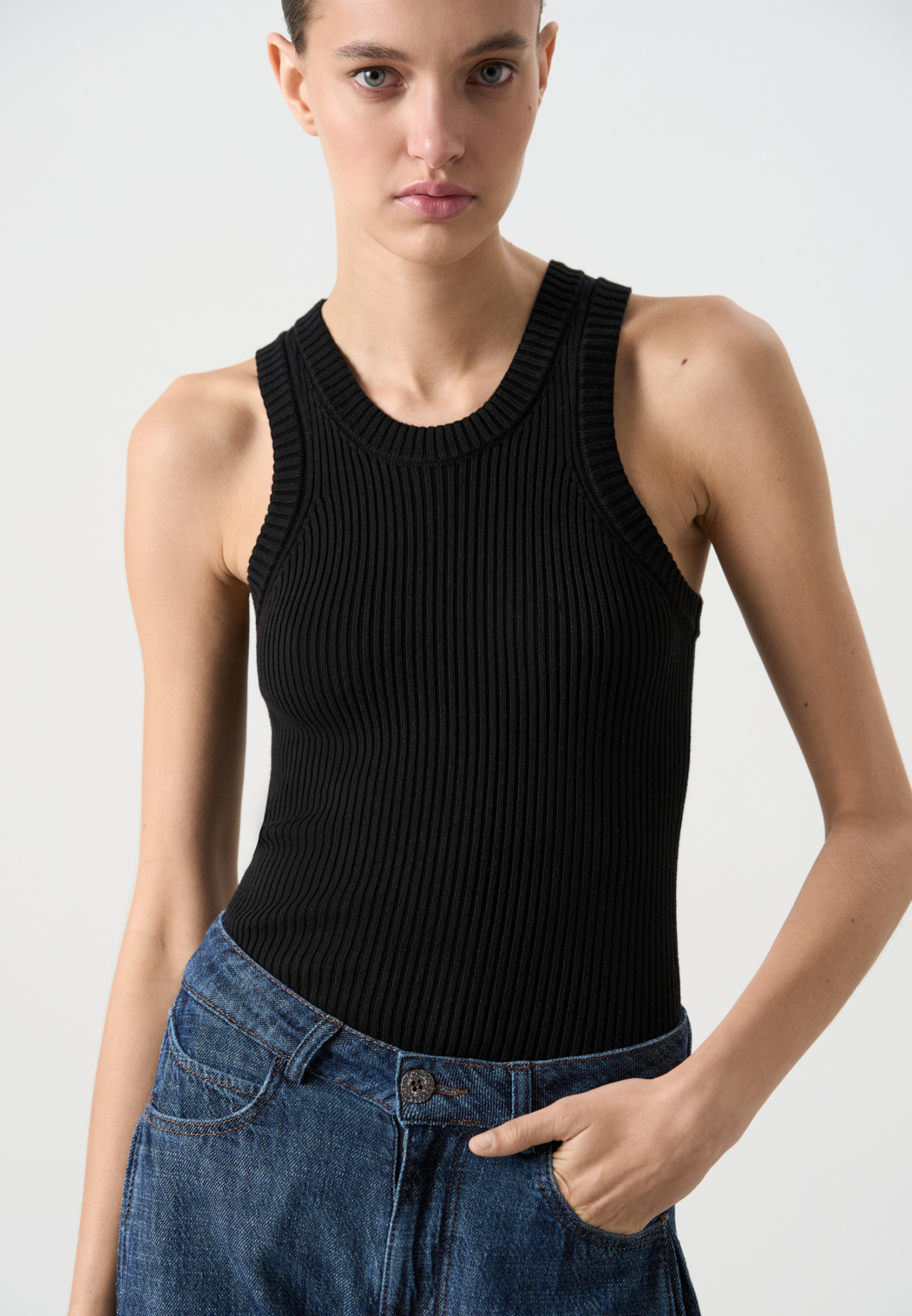 Трикотажный топ в широкий рубчик из хлопка с добавлением вискозы. Модель по фигуре, без рукавов, с глубокой проймой и U-вырезом горловины. 