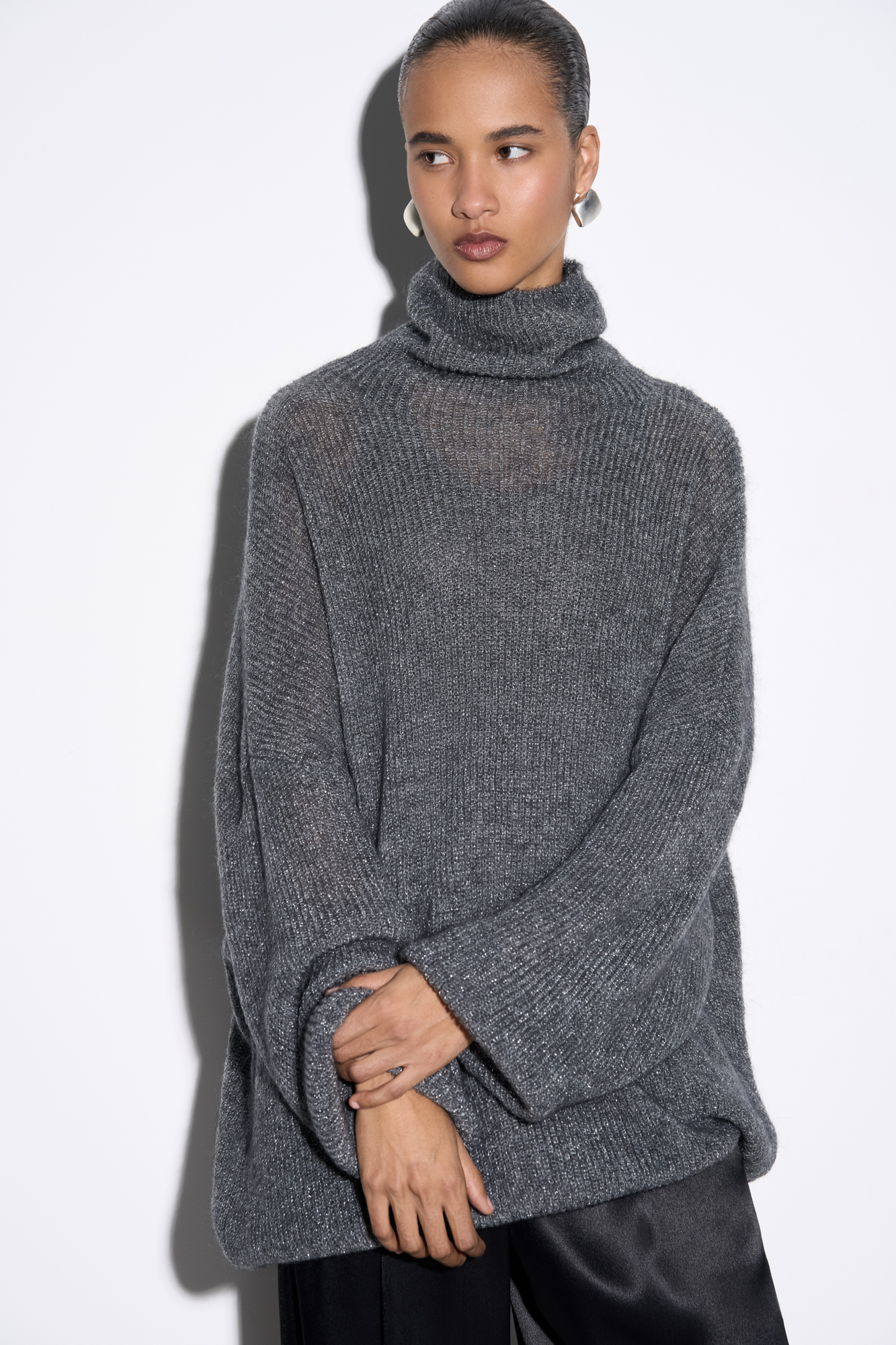 Трикотажный джемпер с люрексом. Модель свободного силуэта со спущенной линией плеча и вывязанным воротником.