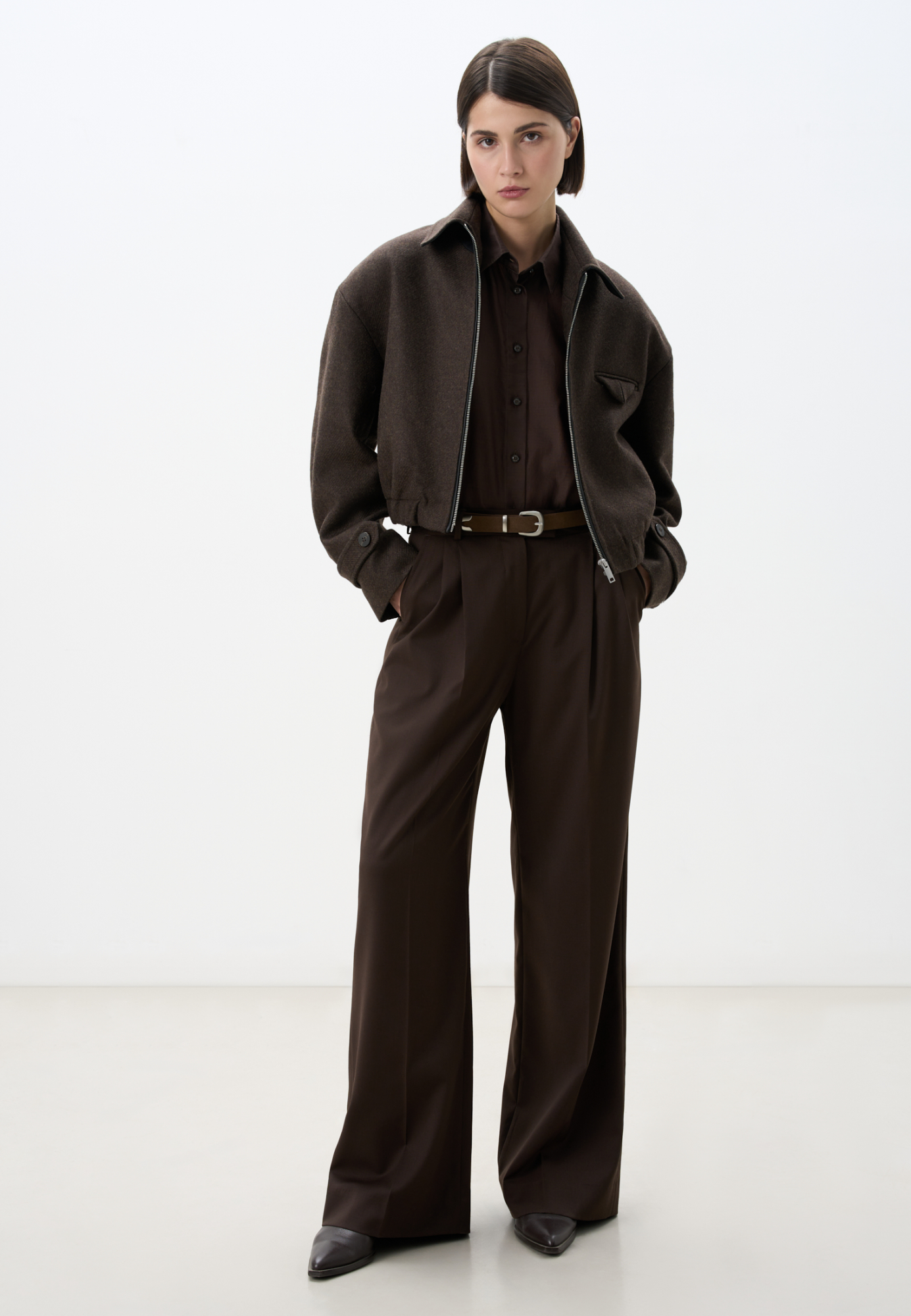 Шерстяной бомбер с отложным с воротником. Модель прямого силуэта с подплечниками и имитацией кармана на груди. Длинные рукава с патами на манжетах. Воротник декорирован вставкой из экокожи. Застежка на молнию. Изделие на подкладке.