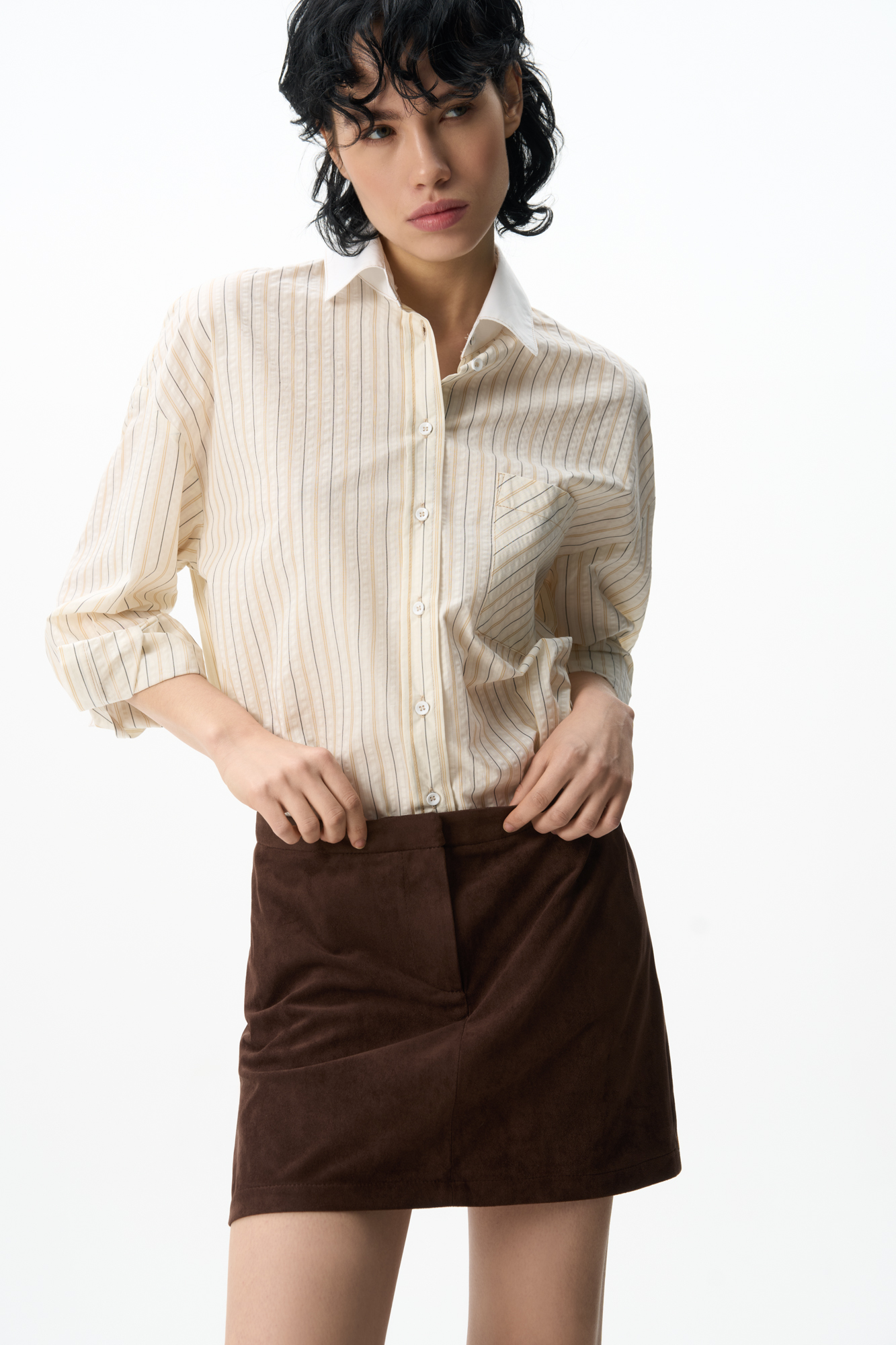 Юбка длины мини из ткани с имитацией внешнего вида и свойств натуральной замши. Застежка на скрытую пуговицу и молнию спереди. 