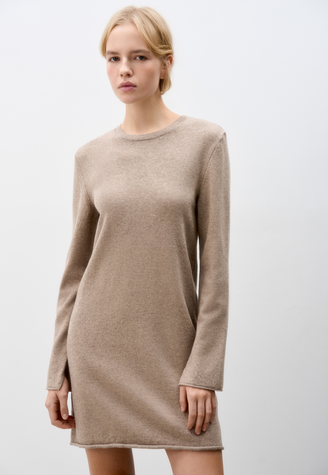 Трикотажное платье длины мини из шерсти с добавлением кашемира. Модель свободного силуэта с длинными рукавами, круглым вырезом горловины и валиком по низу изделия. 