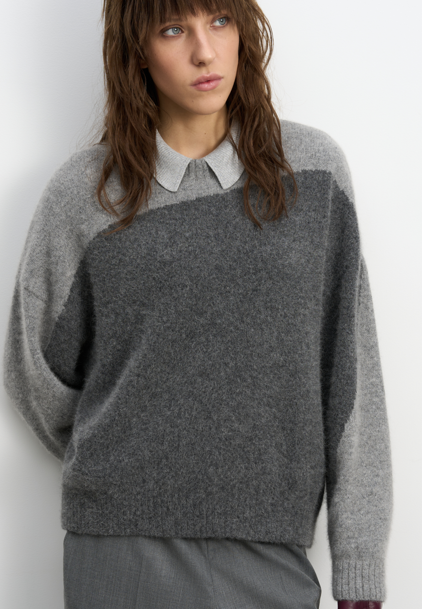 Двухцветный трикотажный джемпер из пуха лисы. Модель свободного силуэта, со спущенной линией плеч и круглым вырезом горловины. Края изделия выполнены в рубчик.