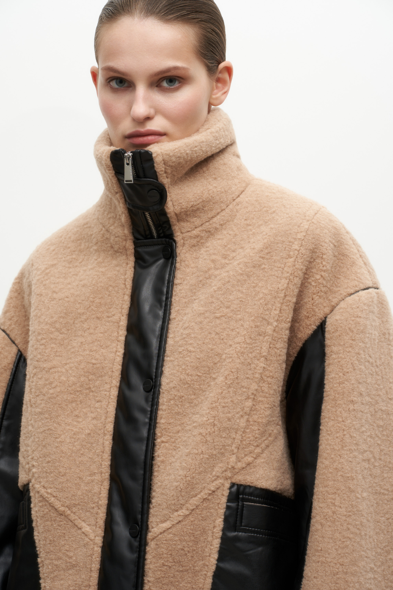 Утепленная куртка из экомеха. Модель свободного силуэта, декорированная вставками из экокожи и брендированным ярлыком на спине. Воротник-стойка, боковые карманы, застежка на молнию и кнопки. Манжеты и низ изделия на резинке. На подкладке.