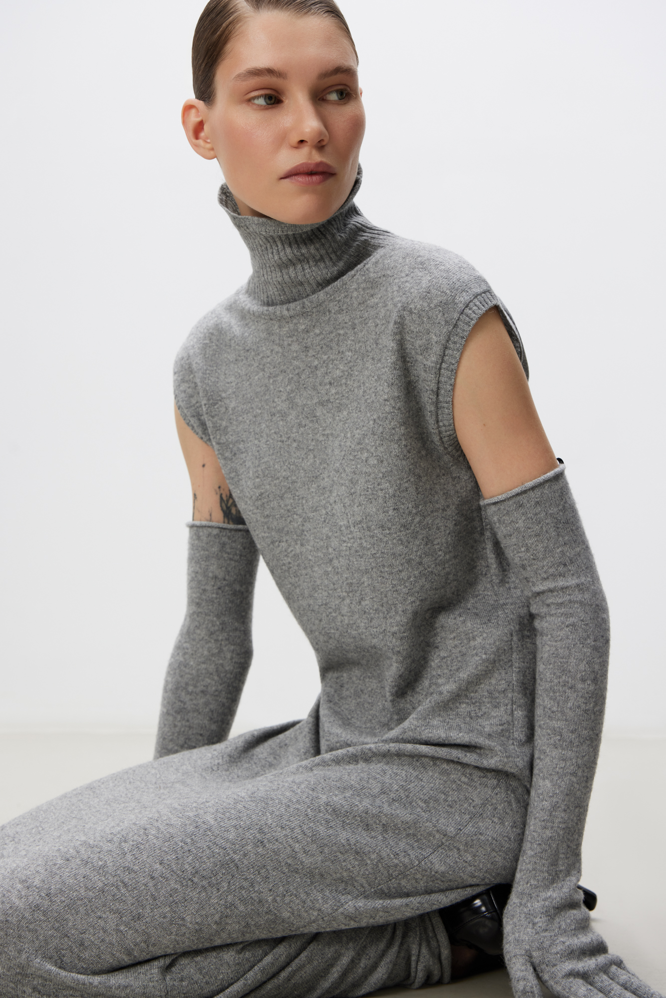 Трикотажное платье длины макси из шерсти и кашемира. Модель прямого кроя без рукавов и высоким воротником.