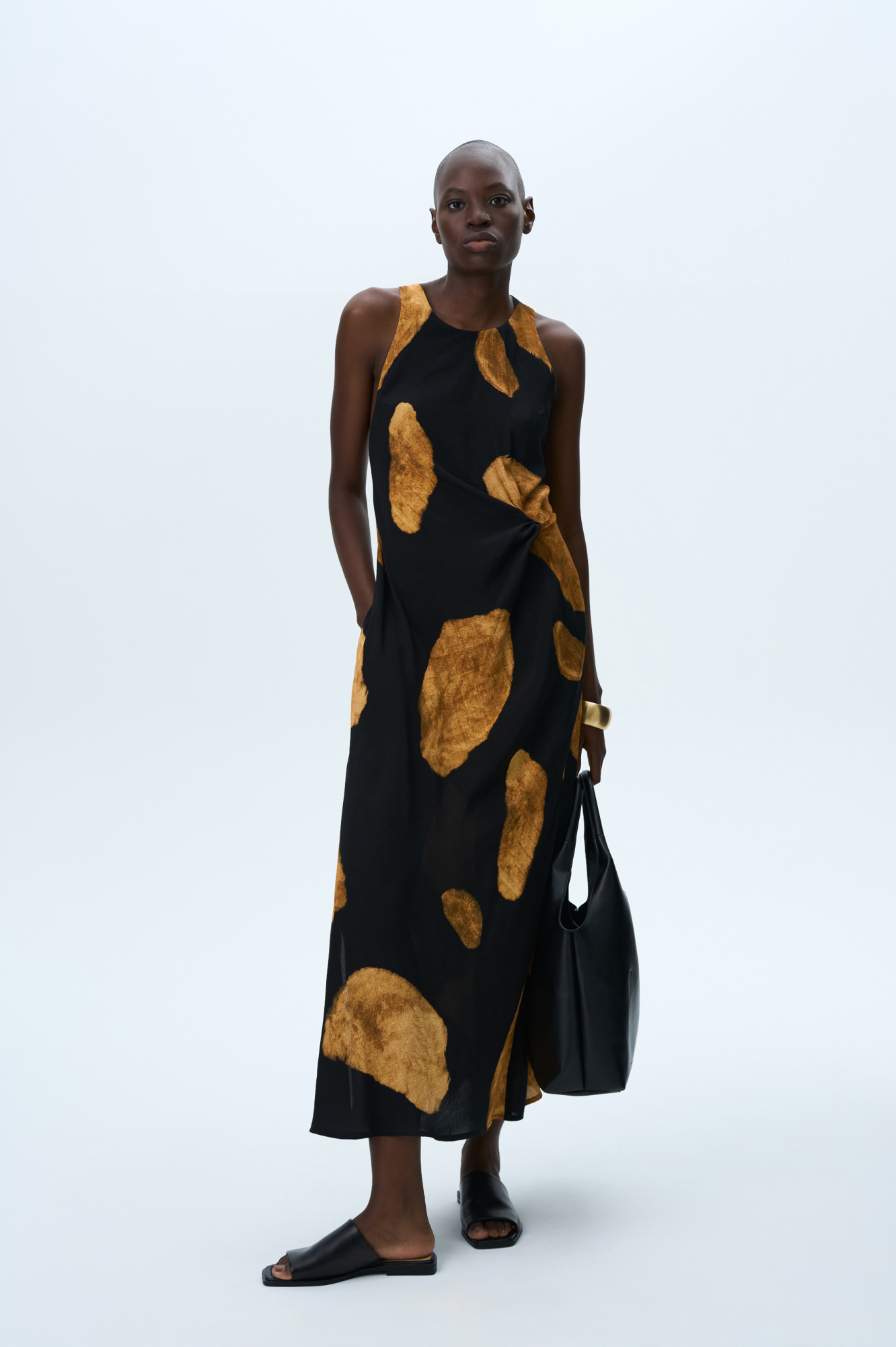 Принтованный сарафан длины миди из 100% вискозы. Модель прямого кроя, с круглым вырезом горловины, без рукавов, на широких бретелях, перекрученных на спине, драпировкой на талии и двумя боковыми карманами. 