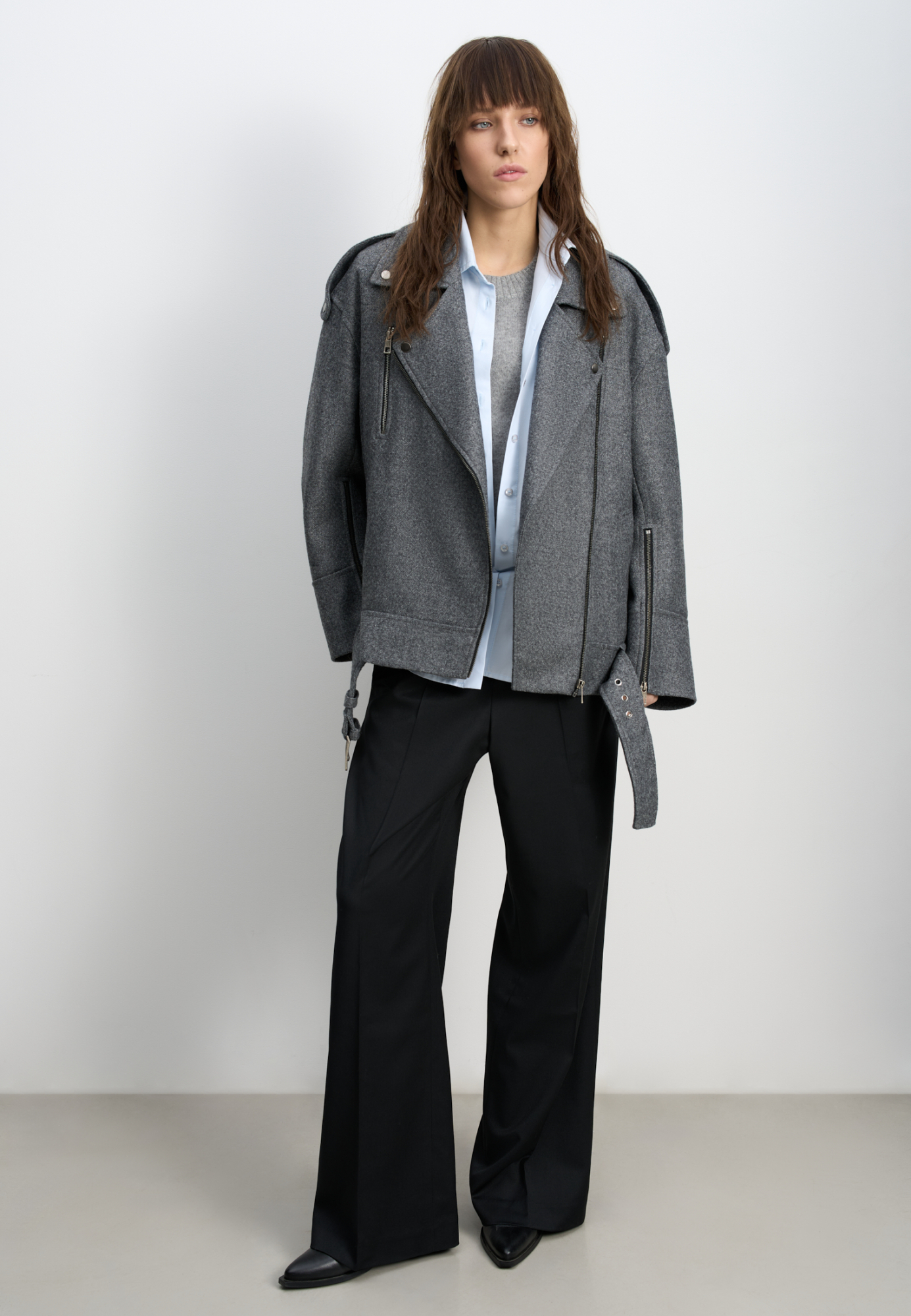 Жакет-косуха из шерсти. Модель свободного силуэта со спущенной линией плеч и косой застежкой. Изделие декорировано эполетами на плечах, широким поясом с пряжкой на талии, боковыми и нагрудным карманом. Изделие на подкладке.