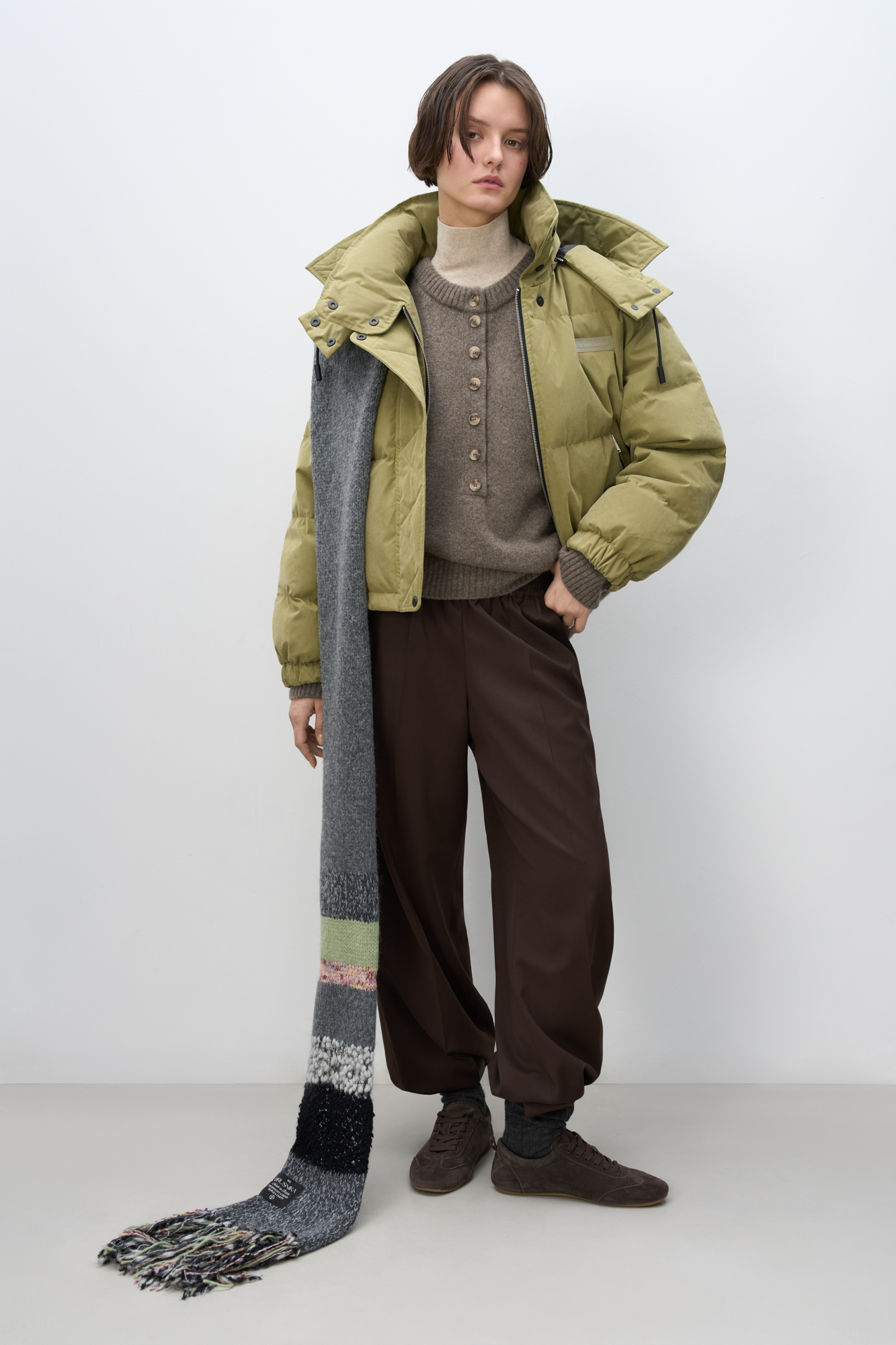 Утепленный пуховик с воротником-стойкой и капюшоном на молнии. Модель свободного силуэта с боковыми карманами, спущенным плечом и брендированным ярлыком на груди. Застежка на потайную молнию и кнопки. Наполнитель натуральный пух 90% перо 10%.