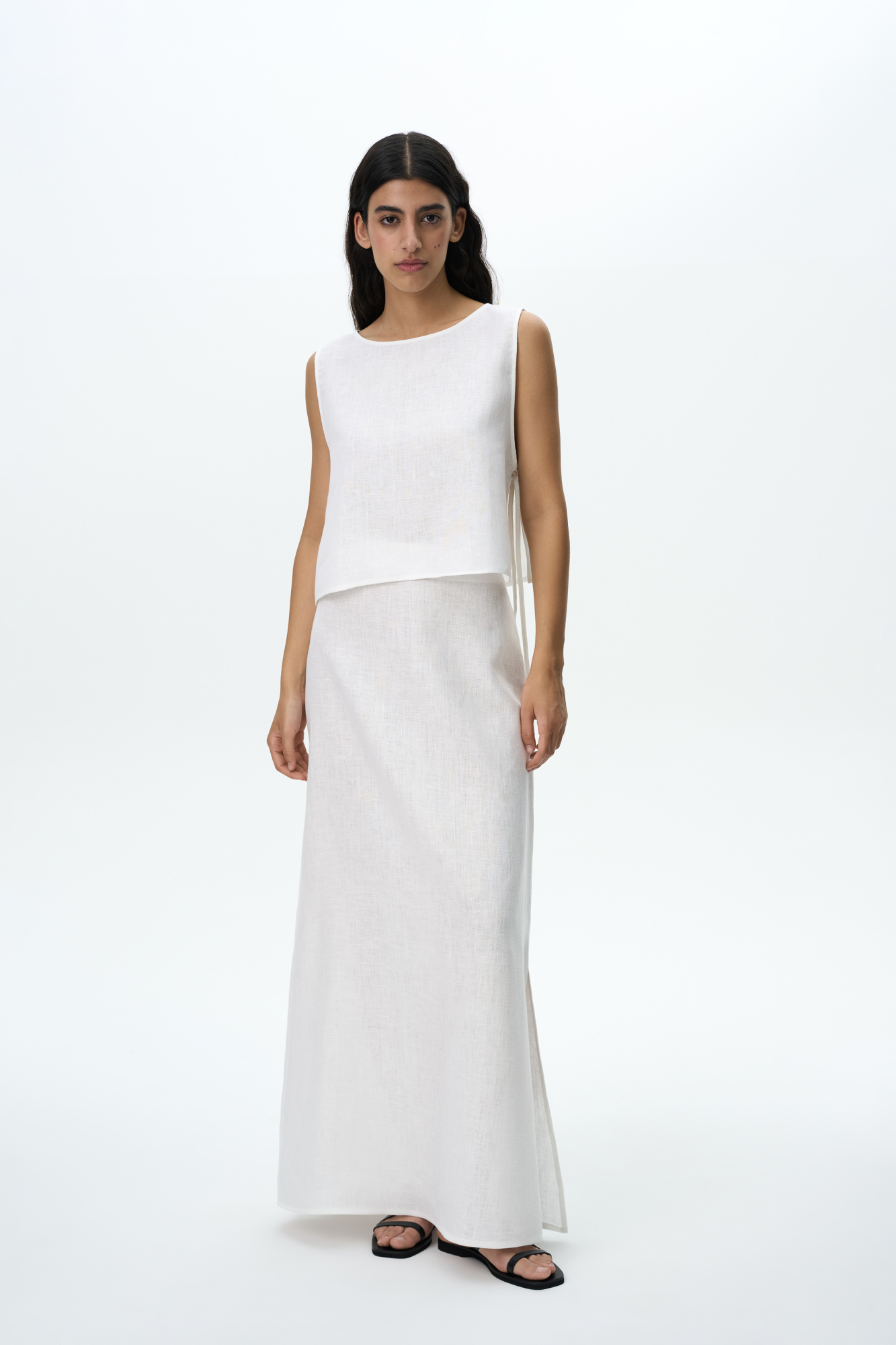 Юбка длины макси из 100% льна. Модель прямого кроя, с небольшим разрезом сбоку, эластичным поясом на резинке и застежкой на молнию. 
