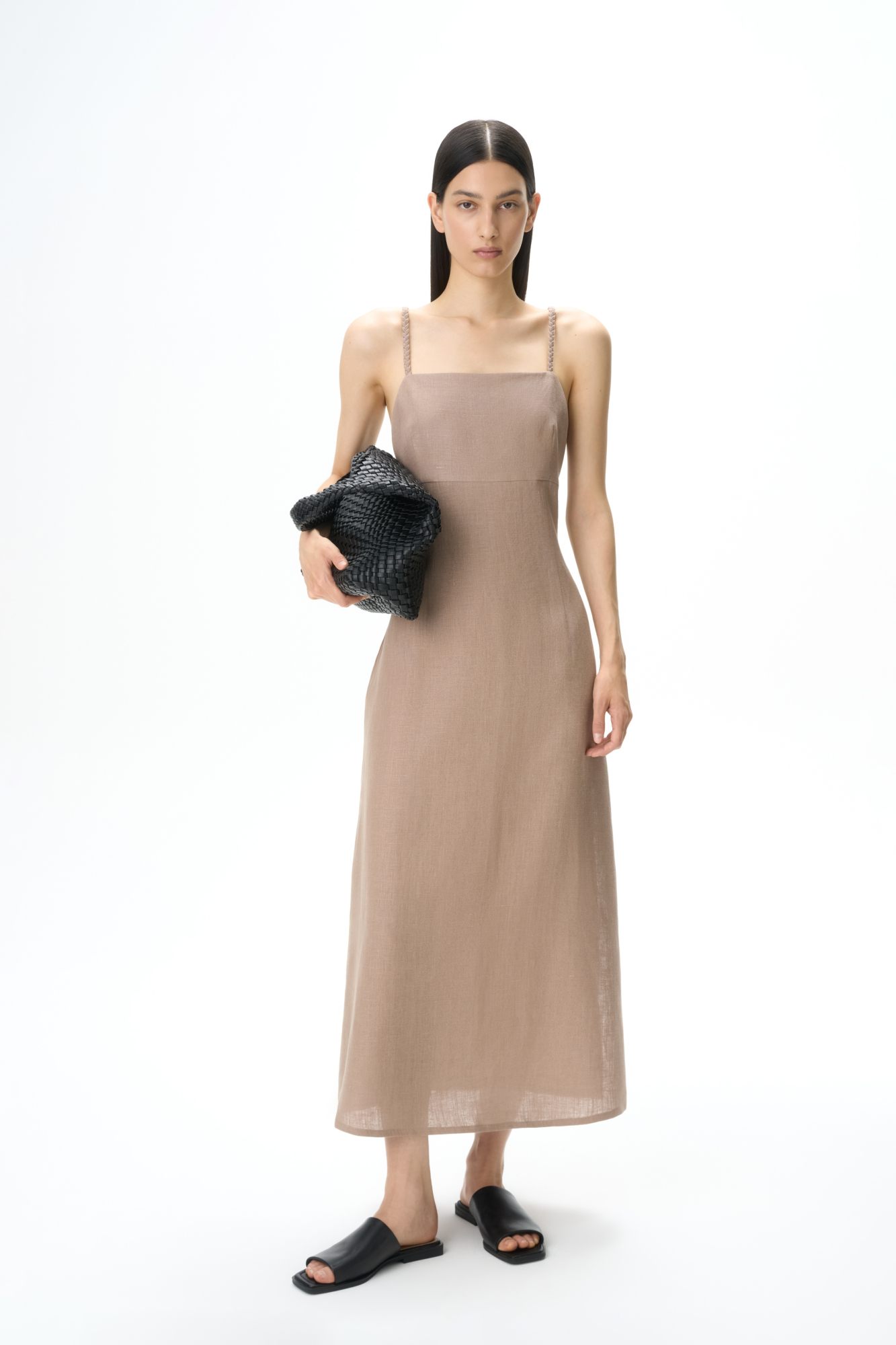 Сарафан длины миди из 100% льна. Модель приталенного силуэта, на тонких бретельках в виде косичек и высоким разрезом сбоку. Спинка изделия выполнена на резинке.