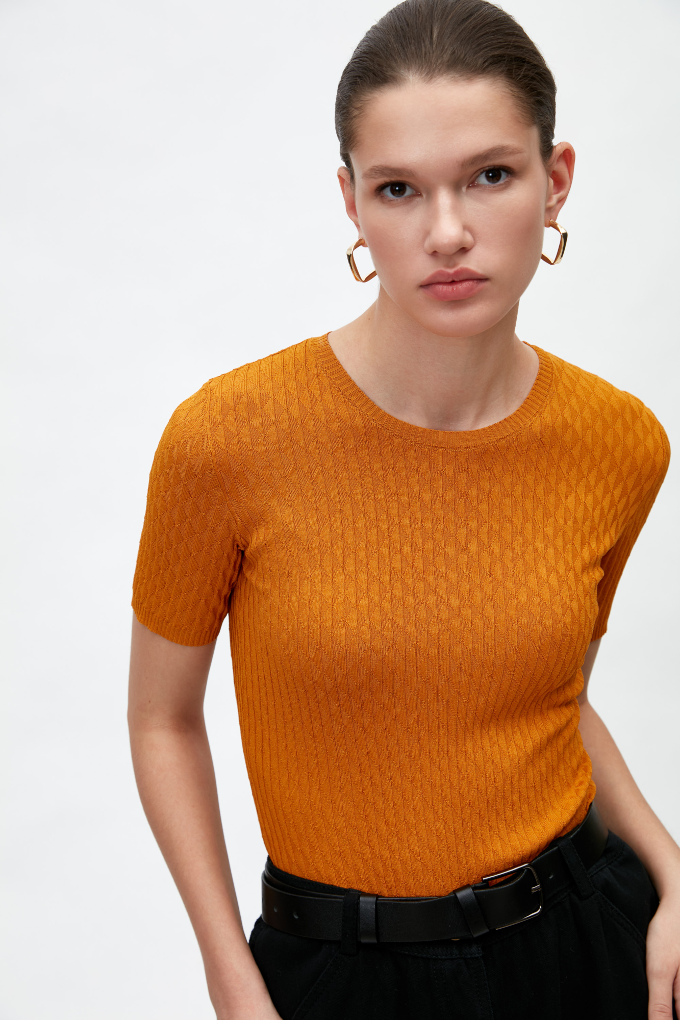 Трикотажная футболка из вискозы с текстурированным узором в виде ромбов. Модель приталенного силуэта с коротким рукавом и круглым вырезом горловины.