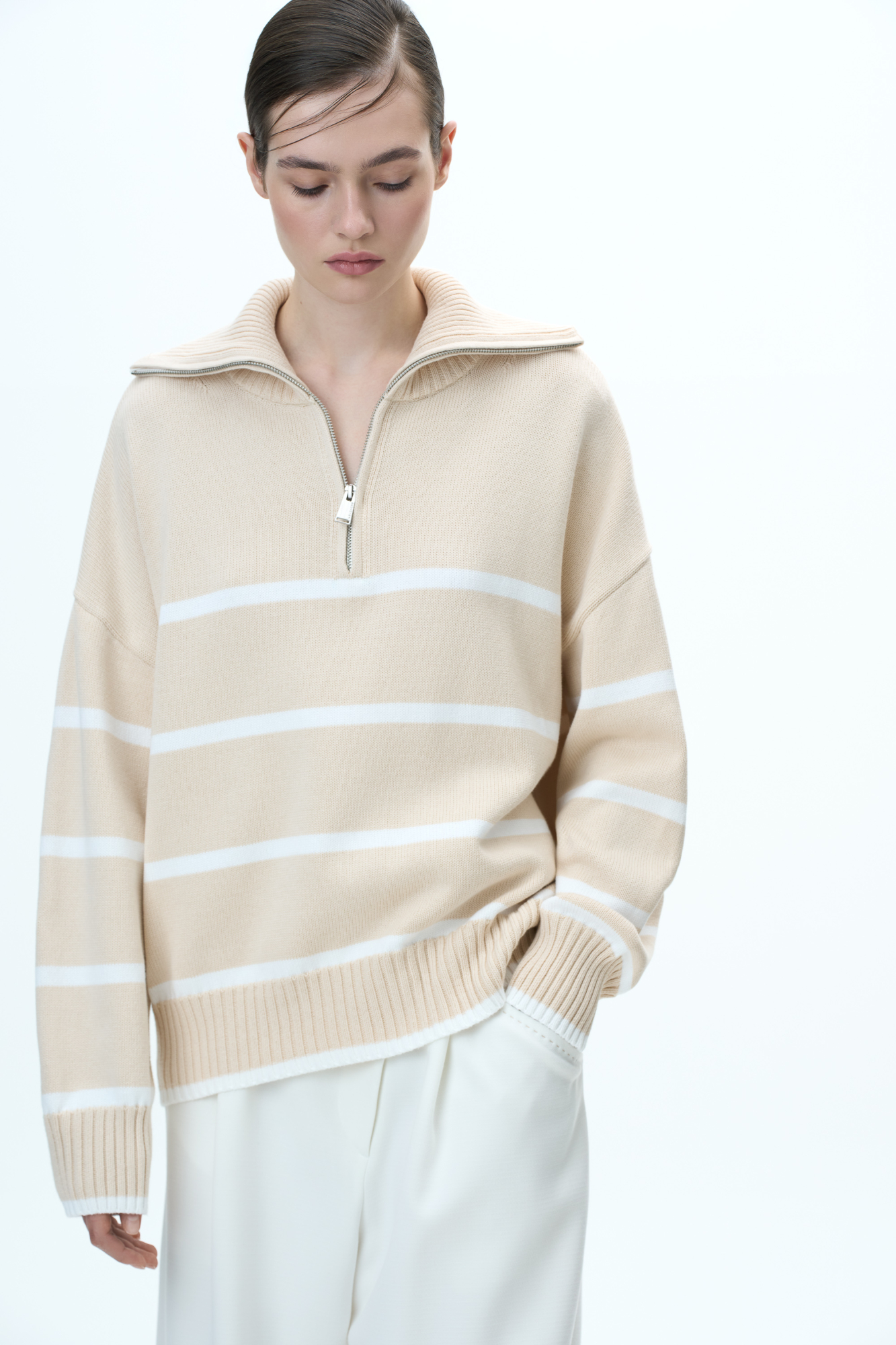 Трикотажный джемпер из 100% хлопка в полоску. Модель свободного силуэта со спущенной линией плеча и воротником-стойкой на молнии.