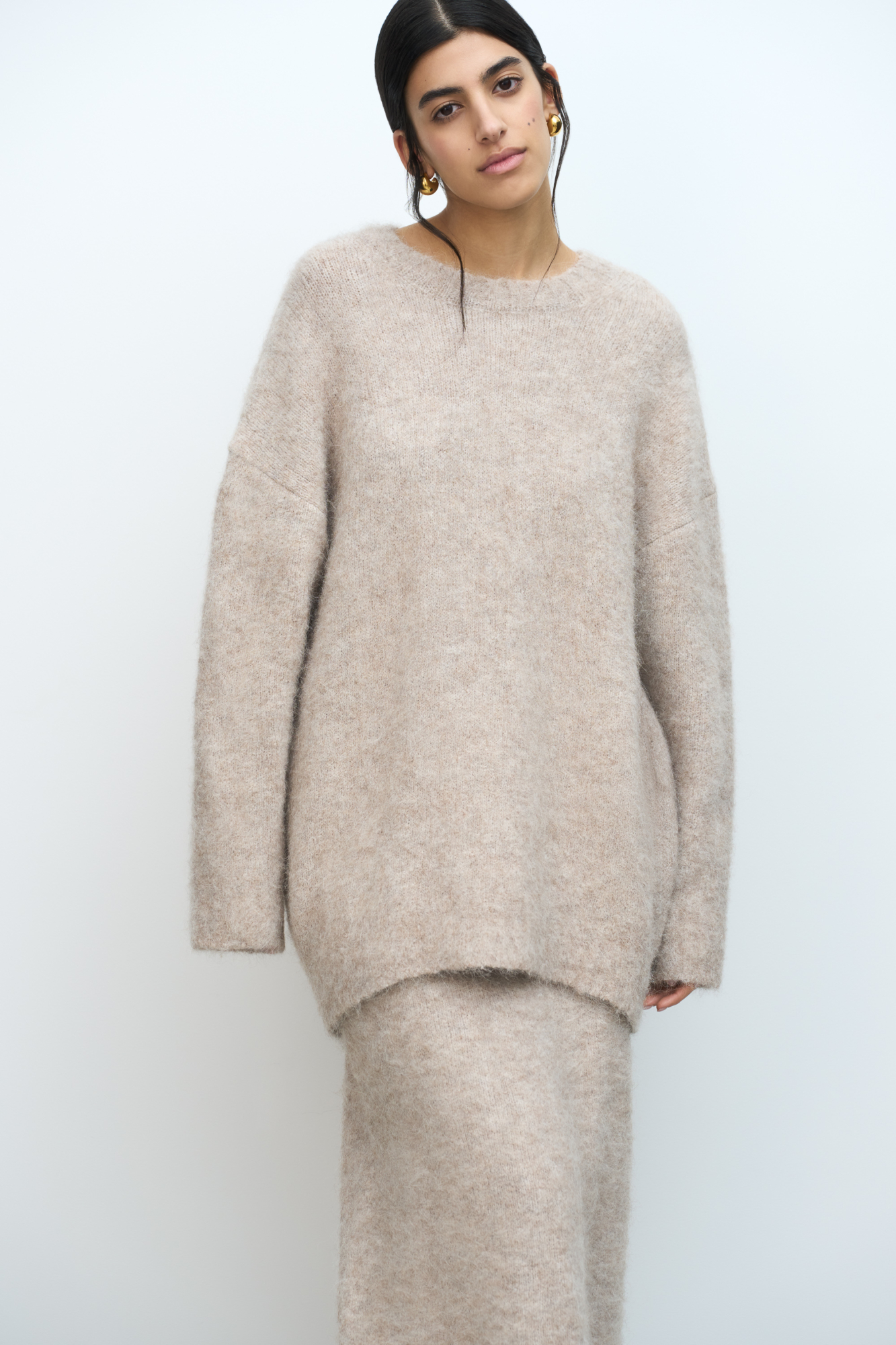 Трикотажный джемпер из пушистой пряжи на основе шерсти альпака. Модель свободного силуэта со спущенной линией плеча. Края изделия в рубчик.