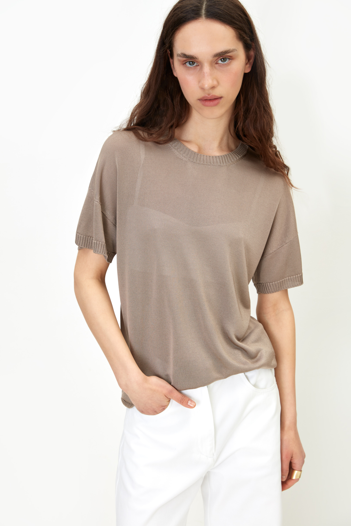 Цельновязаная футболка из 100% вискозы. Модель свободного силуэта, со спущенной линией плеча и круглым вырезом горловины. Края изделия выполнены в рубчик.