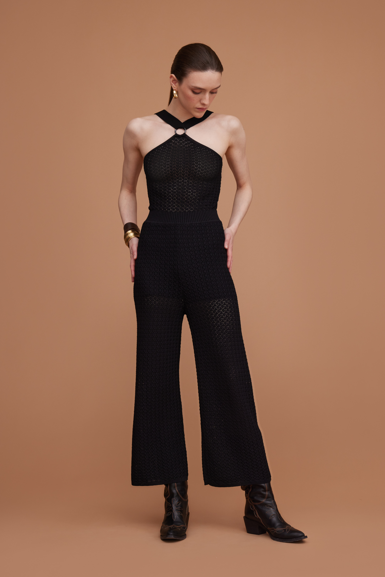 Трикотажный ажурный комбинезон на широких лямках с застежкой на кольце.