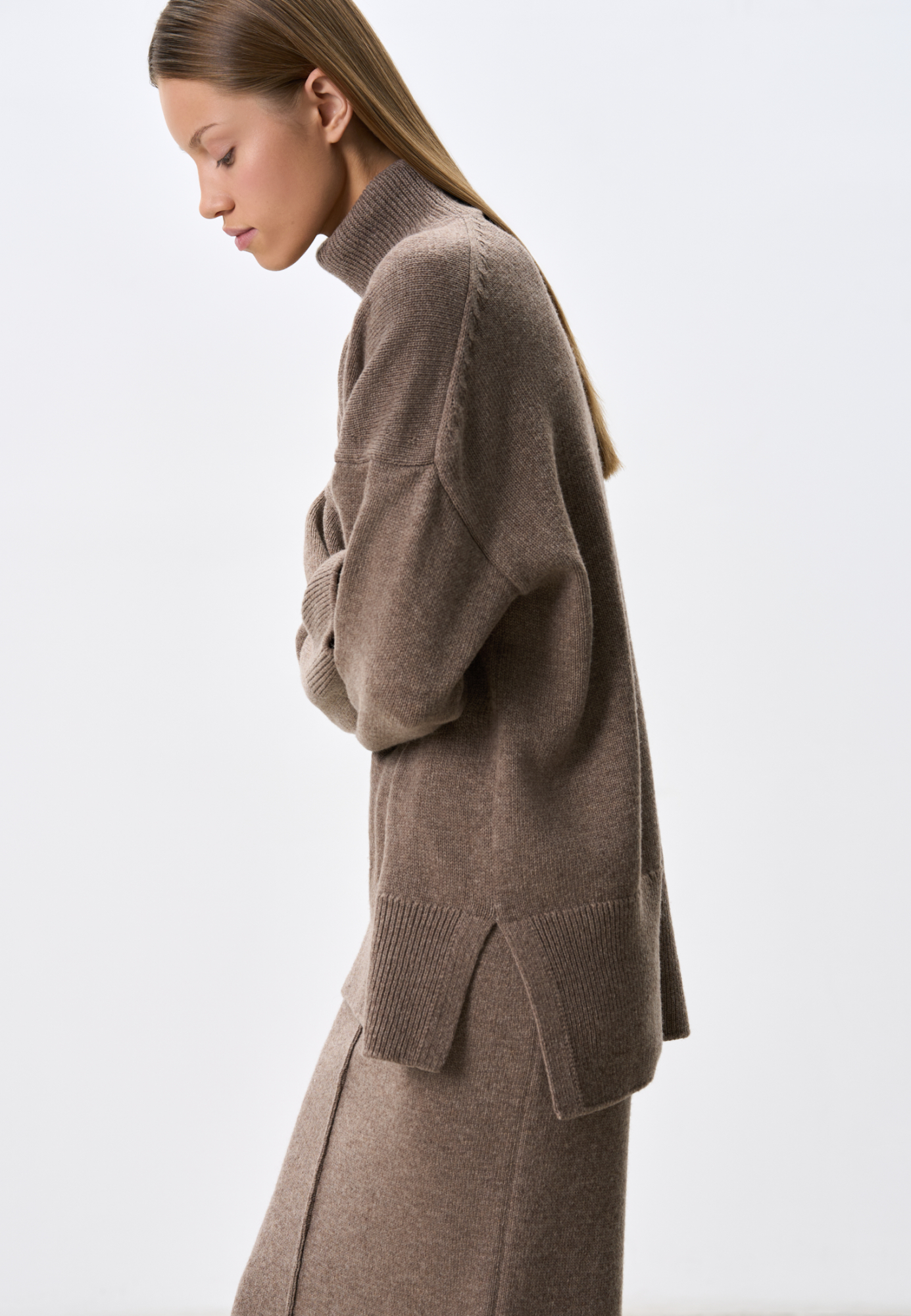 Трикотажный джемпер из кашемира и шерсти. Модель свободного силуэта, со спущенной линией плеч и высоким вывязанным воротом. Манжеты рукавов и низ изделия выполнены в рубчик.