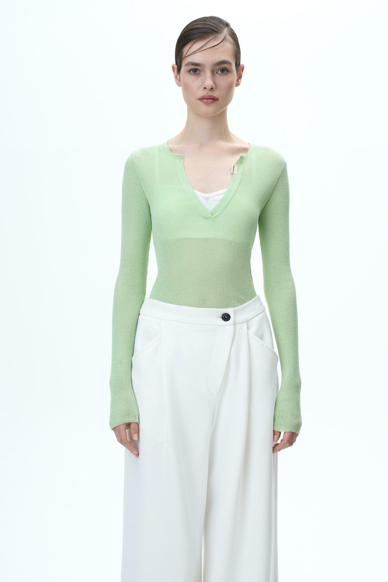 Трикотажный полупрозрачный лонгслив из хлопка с добавлением полиамида. Модель приталенного силуэта с длинными рукавами, V-образным вырезом и брендированным ярлыком на планке.