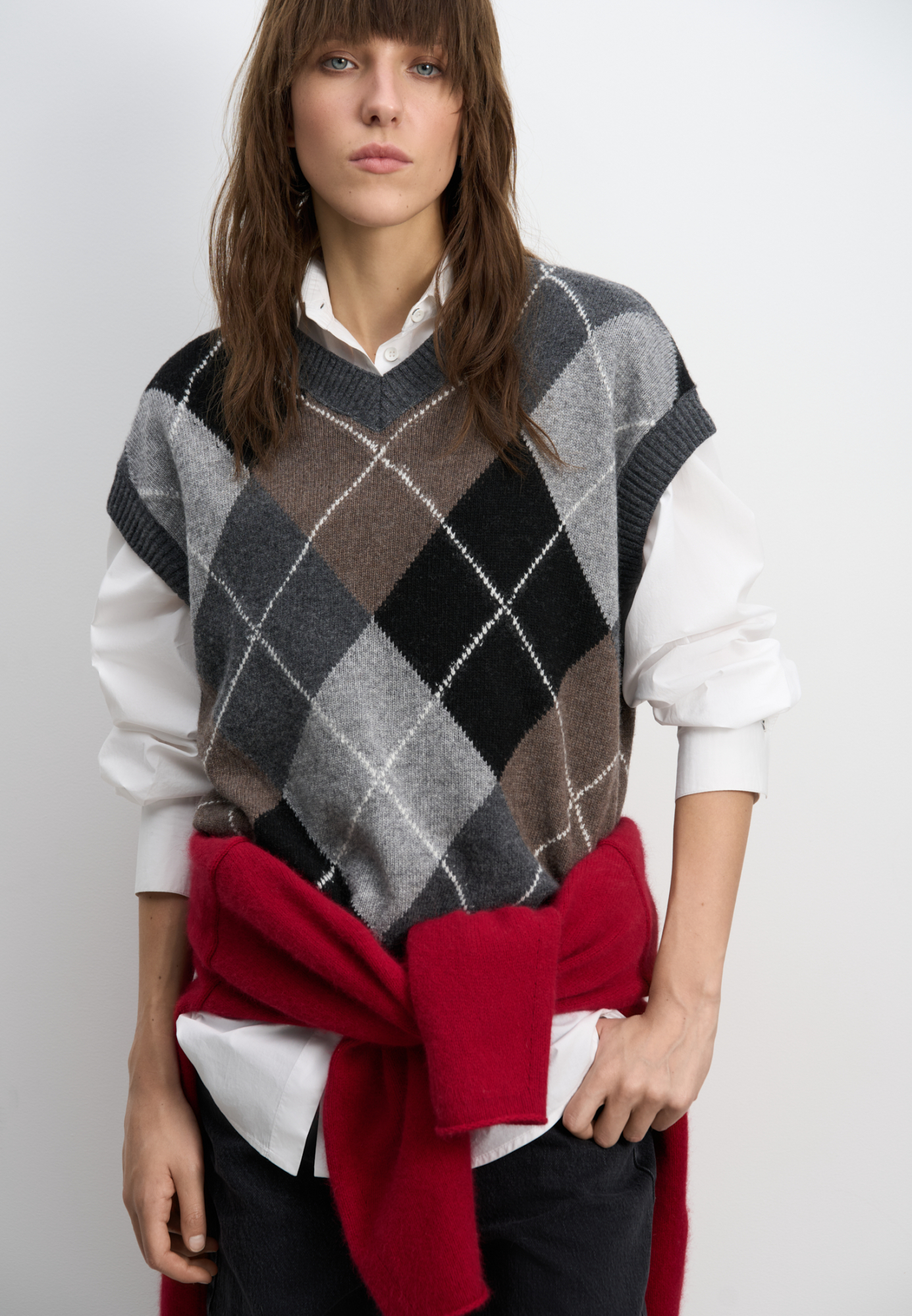 Трикотажный жилет из кашемира с узором аргайл. Модель свободного силуэта без рукавов с неглубоким V-образным вырезом горловины. Края изделия выполнены в рубчик.