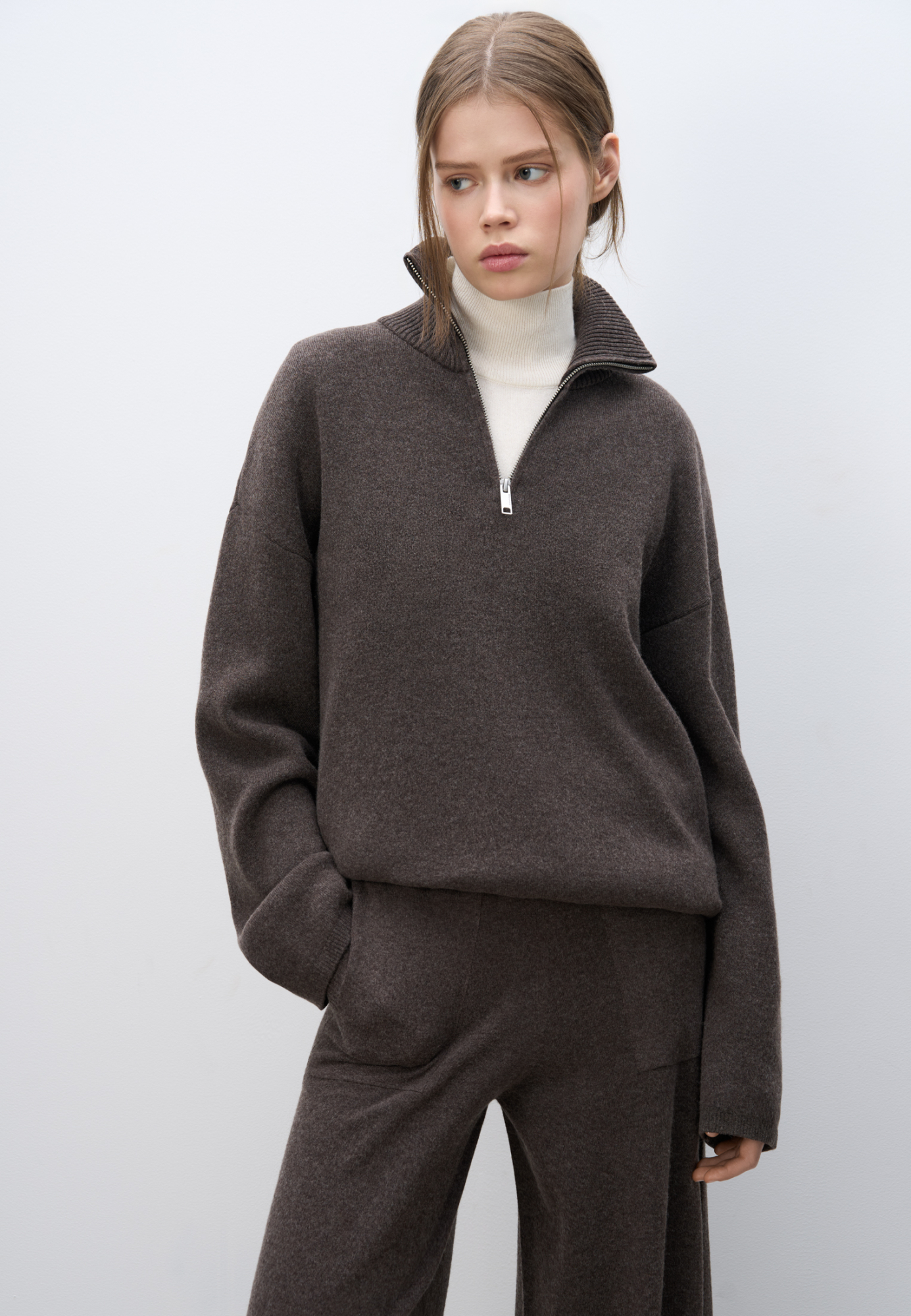 Трикотажный джемпер из кашемира и шерсти. Модель свободного кроя, с высоким воротом на молнии и спущенной линией плеч. Ворот и края изделия выполнены в рубчик.