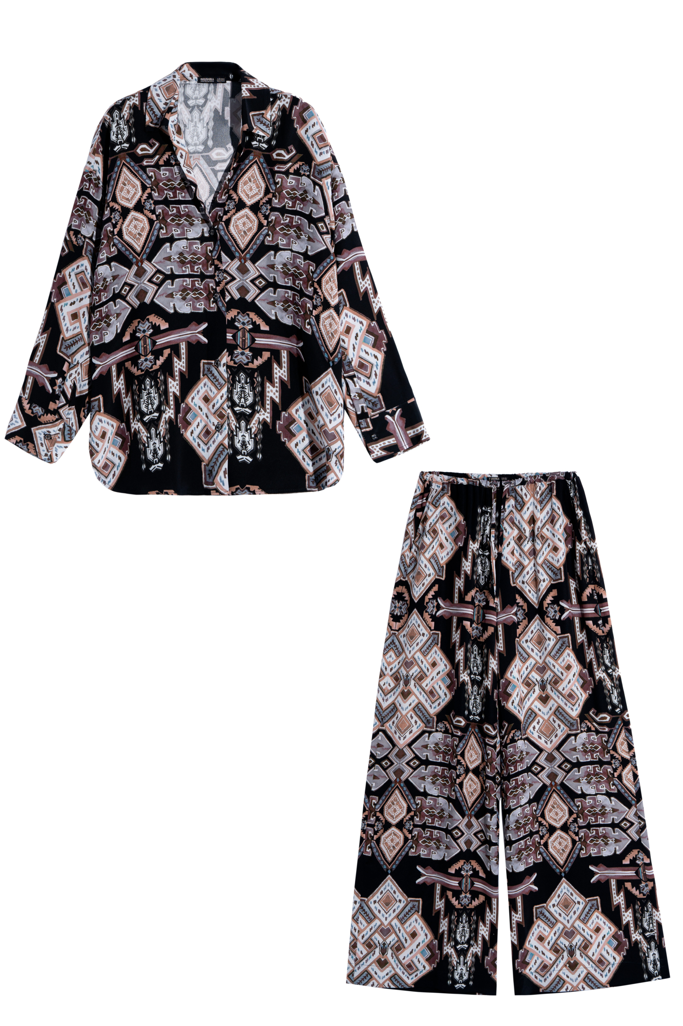 Комплет, состоящий из рубашки и брюк, выполненных из 100% вискозы. Рубашка свободного кроя, с отложным воротником, V-образным вырезом, длинными рукавами с манжетами на пуговицах. Широкие брюки свободного прямого кроя с врезными карманами по бокам, с поясом на узкой резинке, дополненным кулиской. 