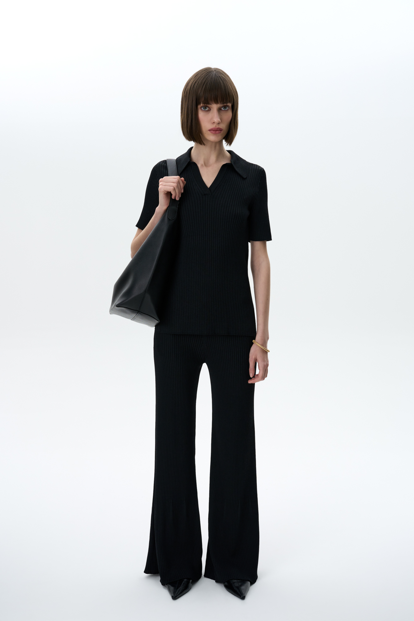 Трикотажные расклешенные брюки из вискозы. Модель приталенного силуэта с боковыми карманами и широким эластичным поясом. Дополнить образ можно футболкой-поло в таком же стиле.