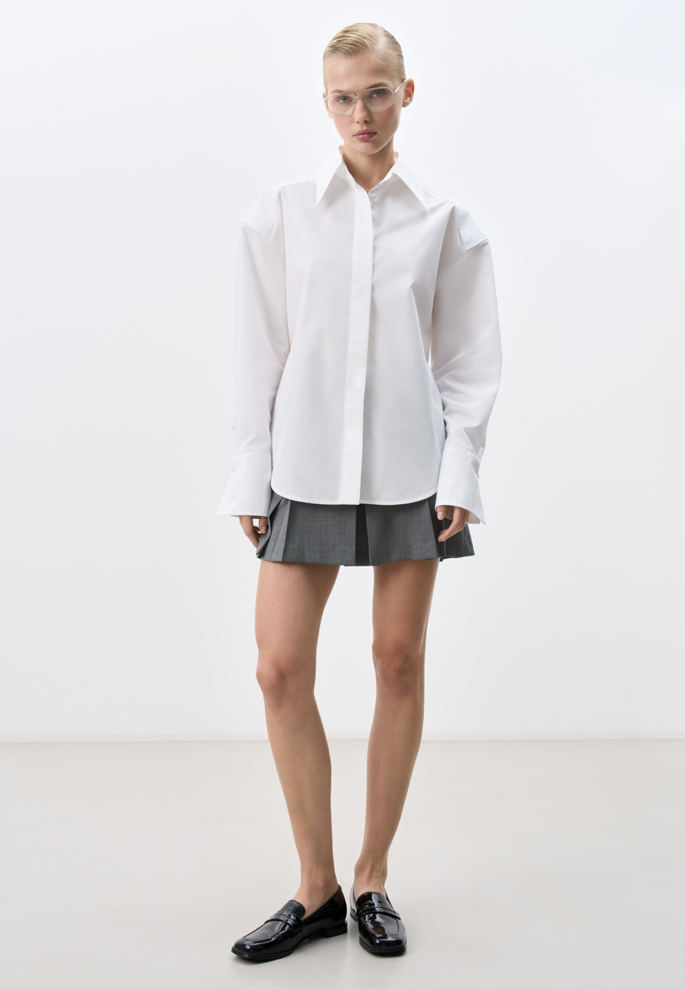 Рубашка из хлопка. Модель прямого кроя, с длинными рукавами с манжетами, классическим отложным воротником, увеличенными плечами и завязкой на спинке. Застежка на пуговицы под планкой. 