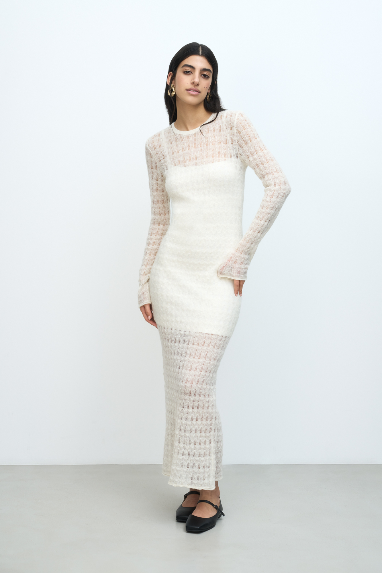 Ажурное платье длины миди из тонкой пряжи супер кид мохера и беби альпака. Модель приталенного силуэта, с длинными рукавами и круглым вырезом горловины. Платье-комбинация из вискозы в комплекте. 