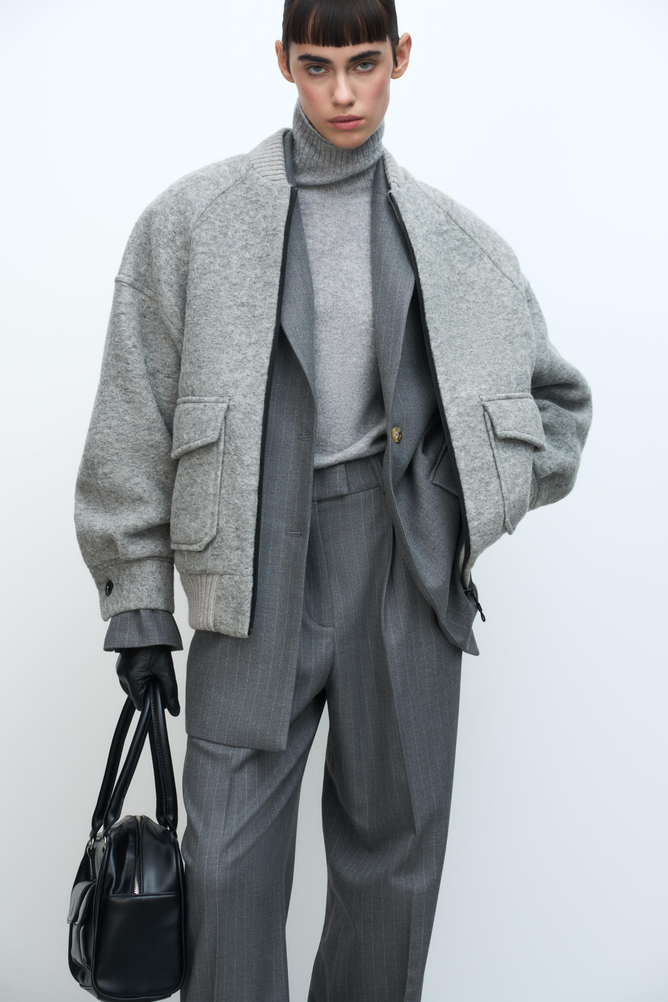 Свободный бомбер из валяной шерсти. Горловина и низ на резинке, манжеты застегиваются на пуговицы. Два передних кармана на клапанах. Застежка на молнию.