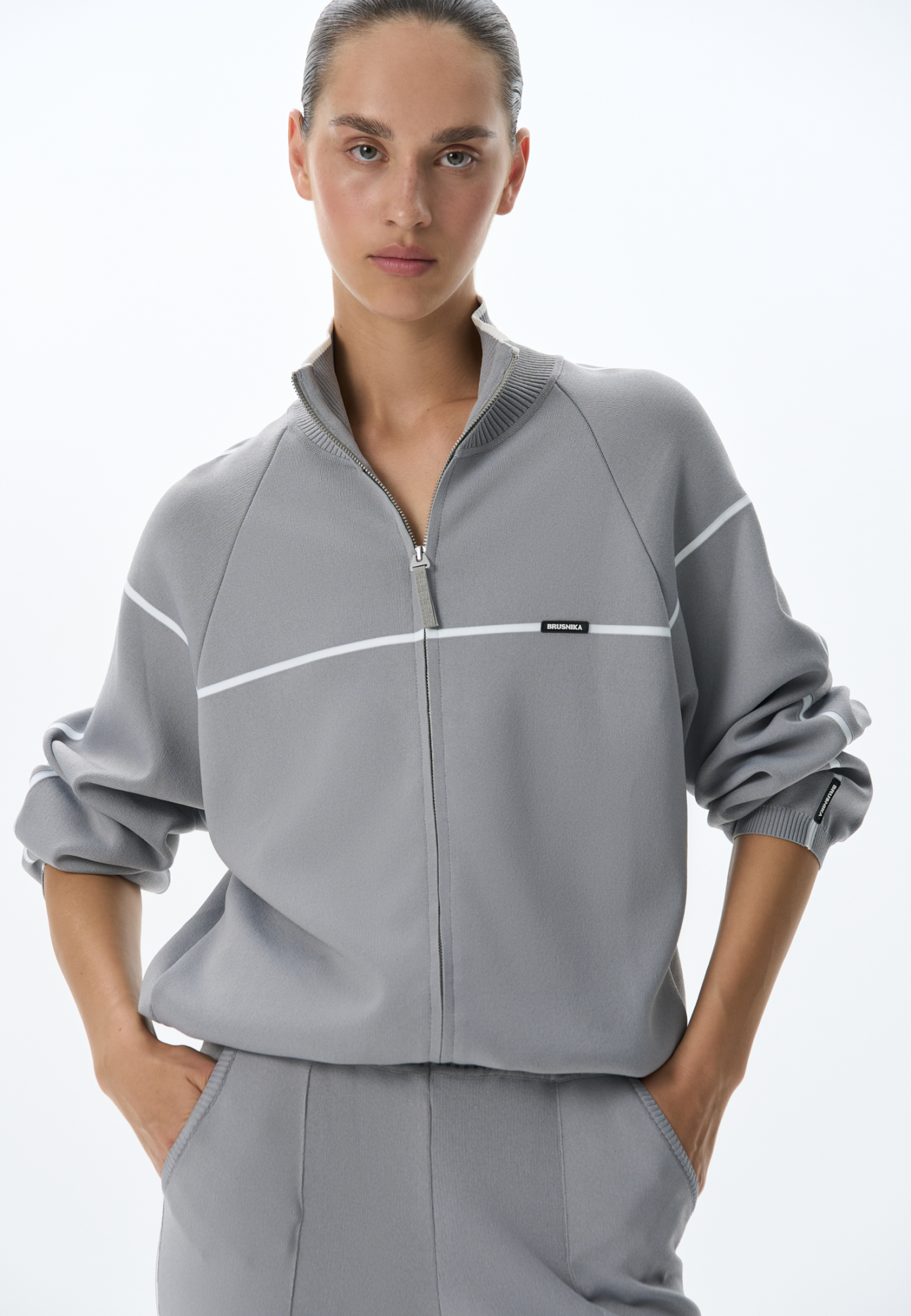 Вискозный трикотажный бомбер спортивного стиля с контрастными лампасами. Модель прямого кроя с длинными рукавами, манжетами на эластичной резинке и воротником-стойкой. По низу изделия предусмотрена регулируемая кулиска. Застежка на молнию.