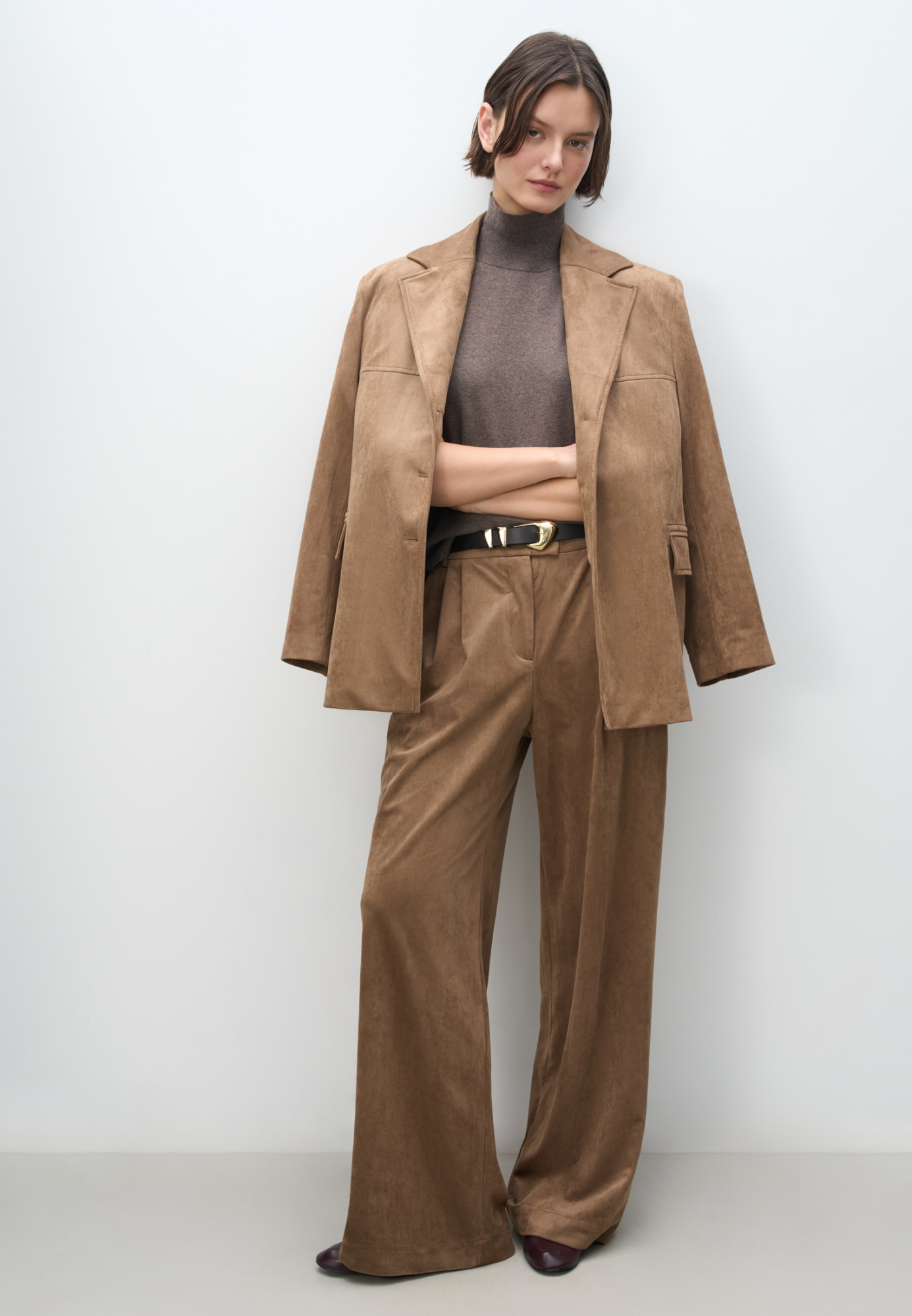 Брюки из ткани с имитацией внешнего вида и свойств натуральной замши. Модель с защипами на талии, шлевками на поясе для ремня. Застежка на скрытую пуговицу и брючный крючок. Отделка строчкой в тон.&nbsp;&nbsp;