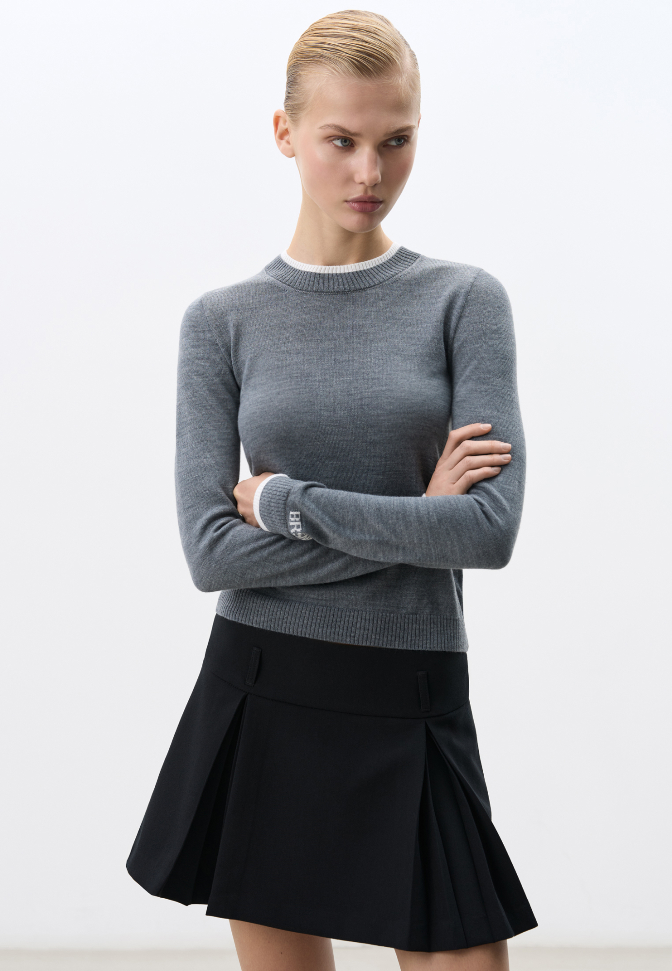 Трикотажный джемпер из шерсти. Модель свободного силуэта с контрастными манжетами и воротничком. Изделие декорировано брендированным жаккардом на рукаве и логотипом на спине.