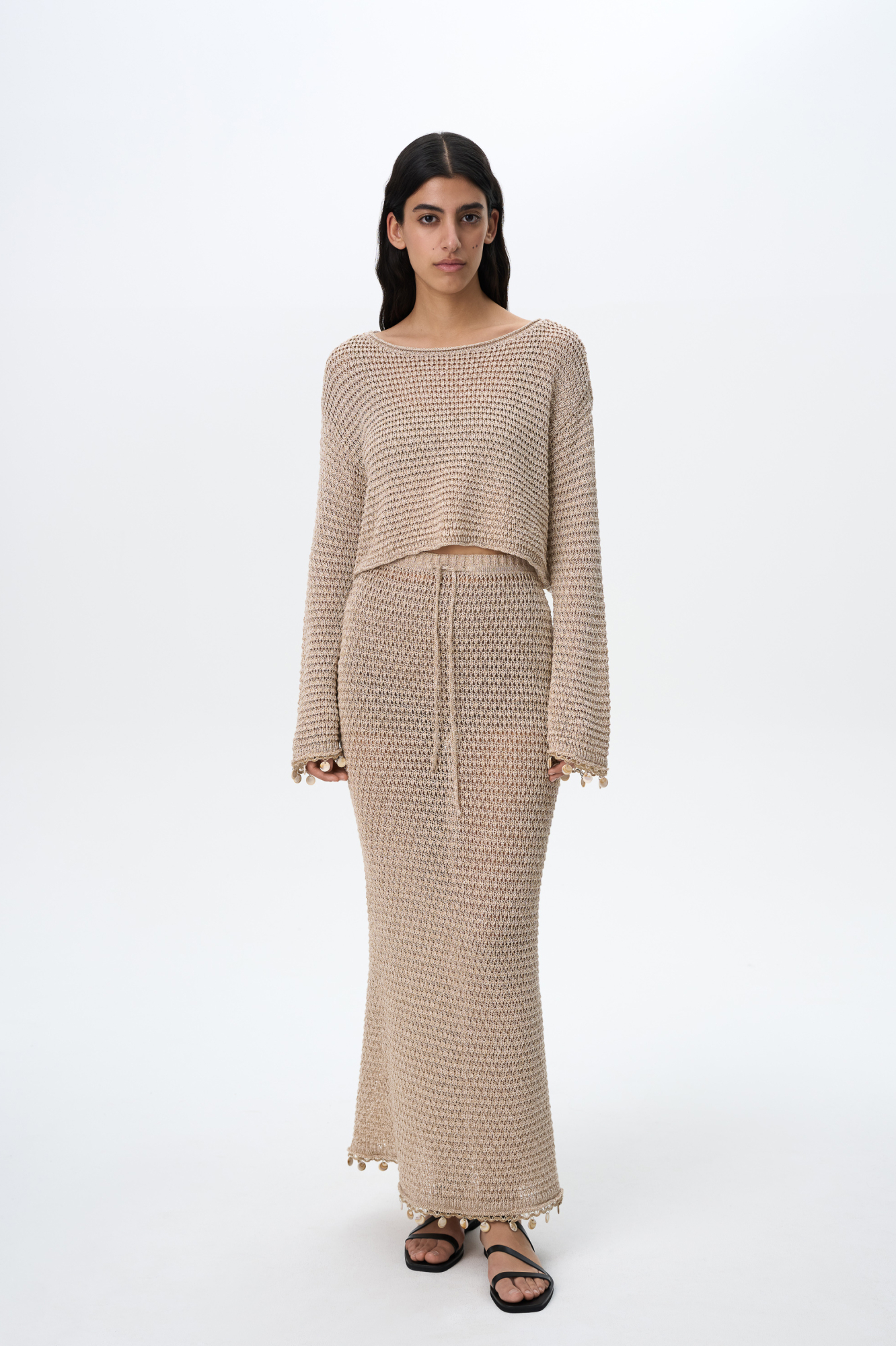 Трикотажная юбка длины макси на эластичном поясе с кулиской. Модель декорирована тесьмой с крупными бусинами. Дополнить образ можно джемпером в таком же стиле.&nbsp;&nbsp;