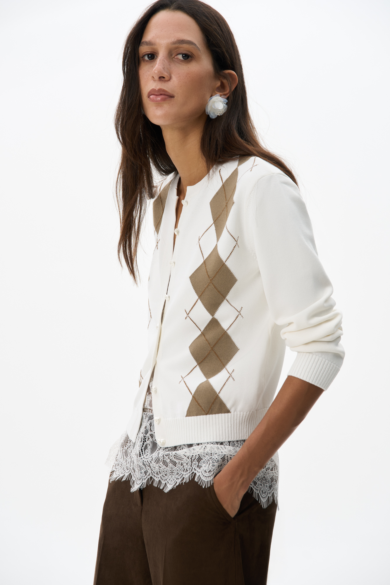 Трикотажный кардиган из вискозы с узором аргайл. Модель свободного силуэта с длинными рукавами, круглым вырезом горловины и застежкой на пуговицы-сердечки. Края изделия выполнены в рубчик.