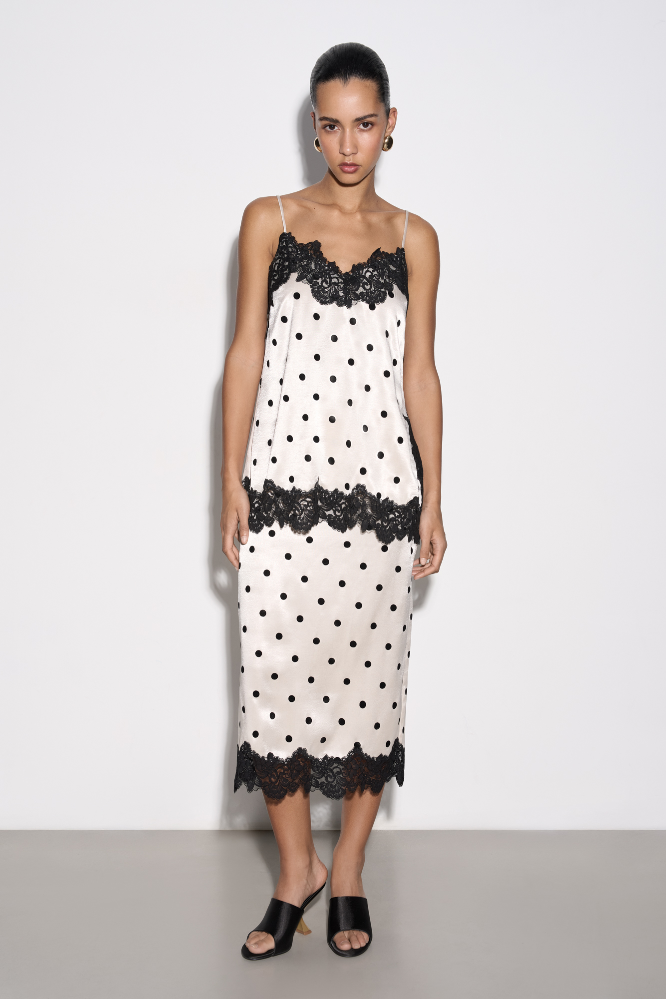 Атласная юбка в горох длины миди. Модель по фигуре с застежкой на&nbsp;&nbsp;потайную молнию. Подол изделия декорирован кружевом.