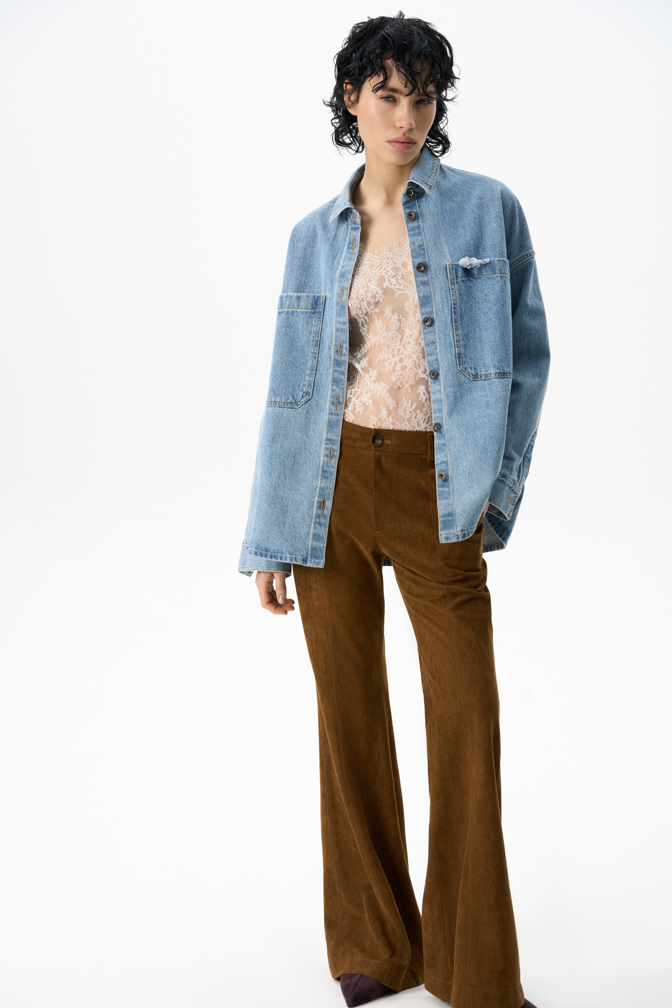 Брюки клеш из ткани с имитацией внешнего вида и свойств натуральной замши. Модель&nbsp;&nbsp;со шлевками на поясе для ремня, боковыми карманами и стрелками. Застежка на&nbsp;&nbsp;пуговицу и молнию. Отделка строчкой в тон.