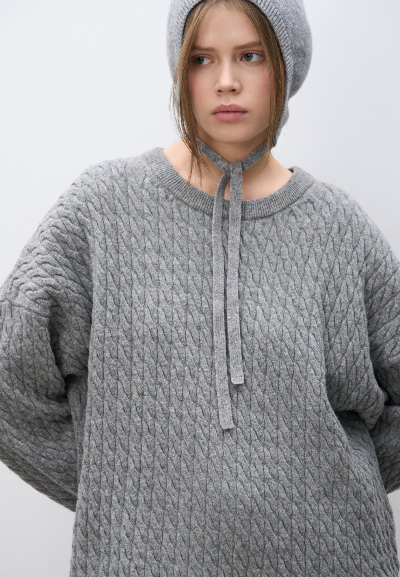 Трикотажный джемпер с объемными косами из 100% шерсти мериноса экстрафайн. Модель свободного силуэта, со спущенной линией плеч и круглым вырезом горловины, оформленным двойной бейкой. Края изделия выполнены в мелкий рубчик.