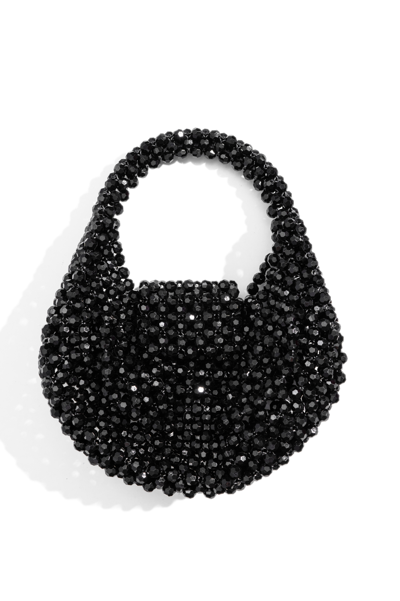 Сумочка полукруглой формы, выполненная путем переплетения ограненных бусин одинакового диаметра. Модель с одной короткой ручкой. Высота изделия составляет 18 см, длина ручки - 12 см.