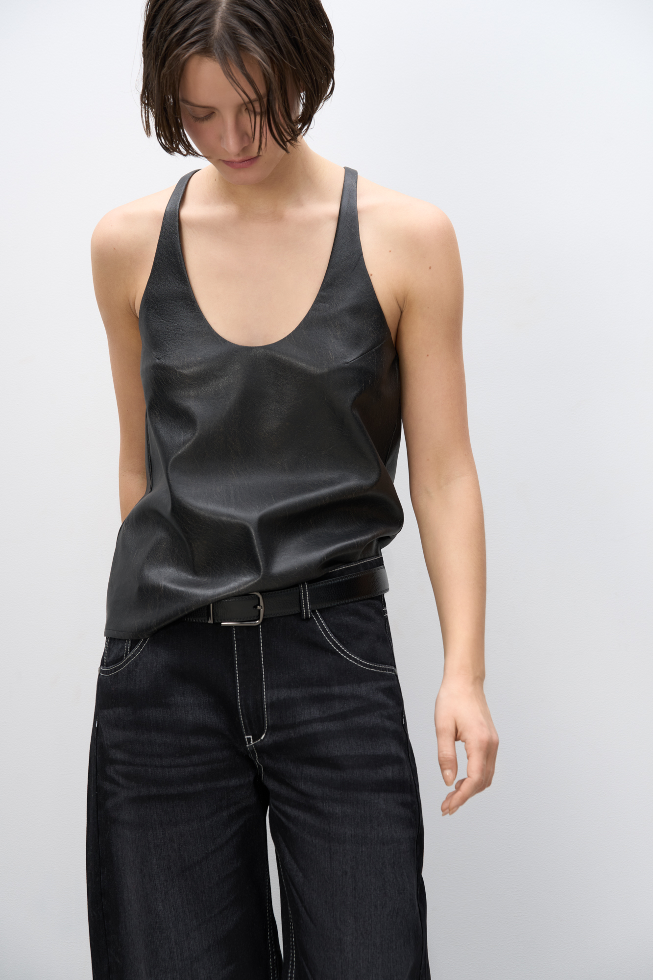 Топ из текстурной экокожи. Модель свободного силуэта на тонких бретельках и глубоким вырезом декольте.