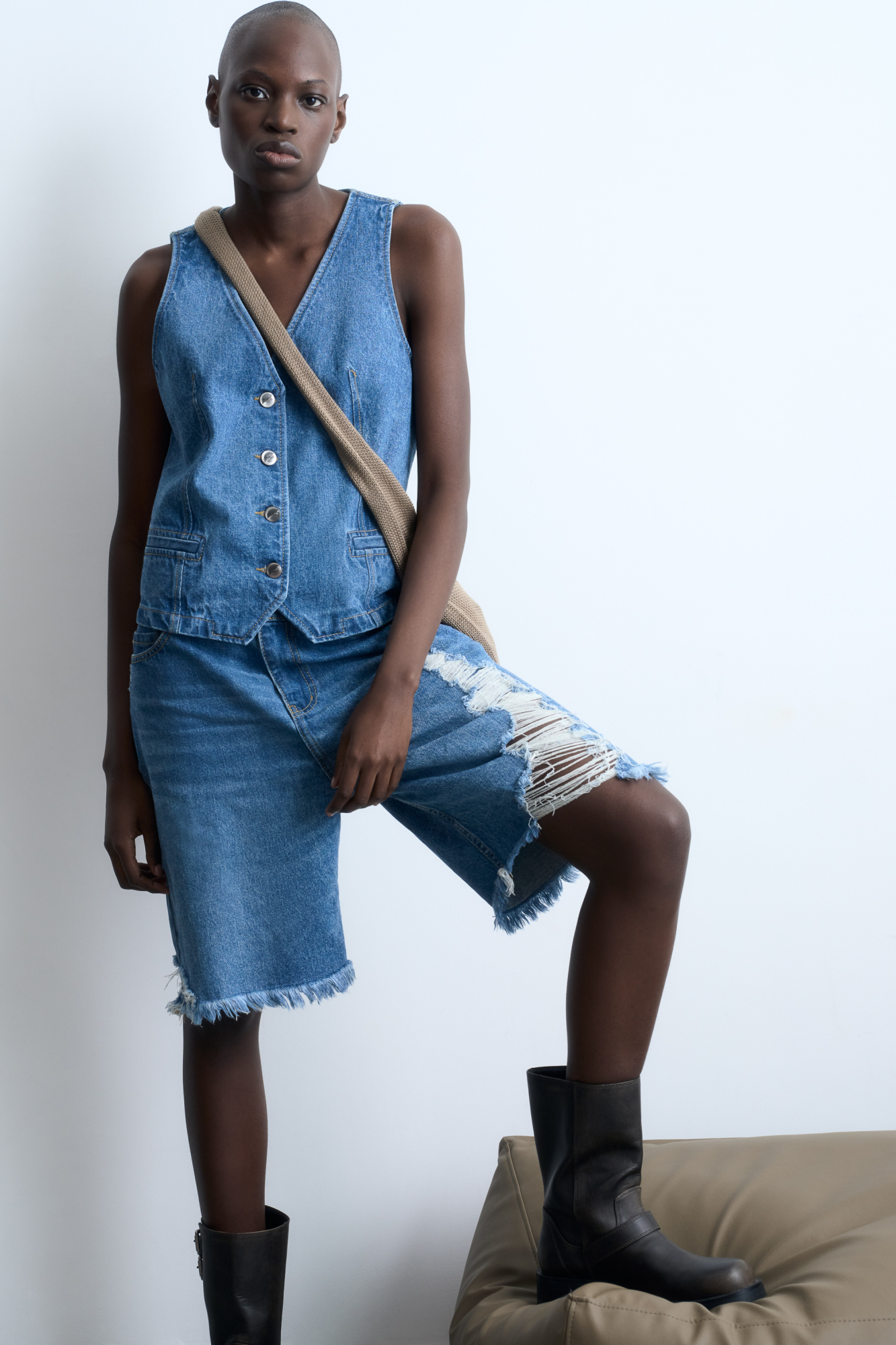 Джинсовые шорты с разрезами в стиле гранж и необработанным низом. Дополнить образ можно жилетом.