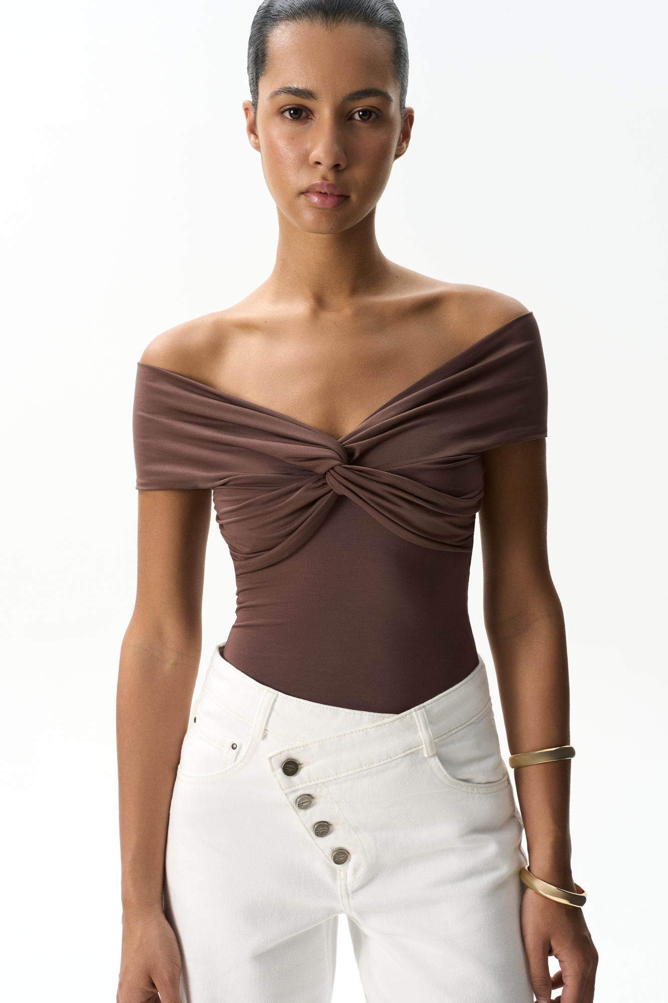 Топ из модала с открытой линией плеч. Модель приталенного силуэта, без рукавов. Изделие декорировано перекрутом на груди и драпировкой на лифе.
