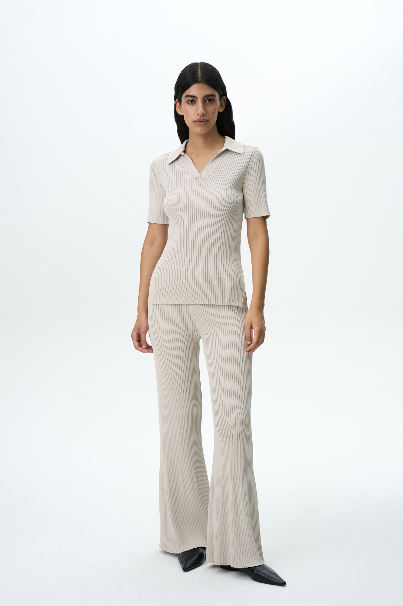 Трикотажные расклешенные брюки из вискозы. Модель приталенного силуэта с боковыми карманами и широким эластичным поясом. Дополнить образ можно футболкой-поло в таком же стиле.